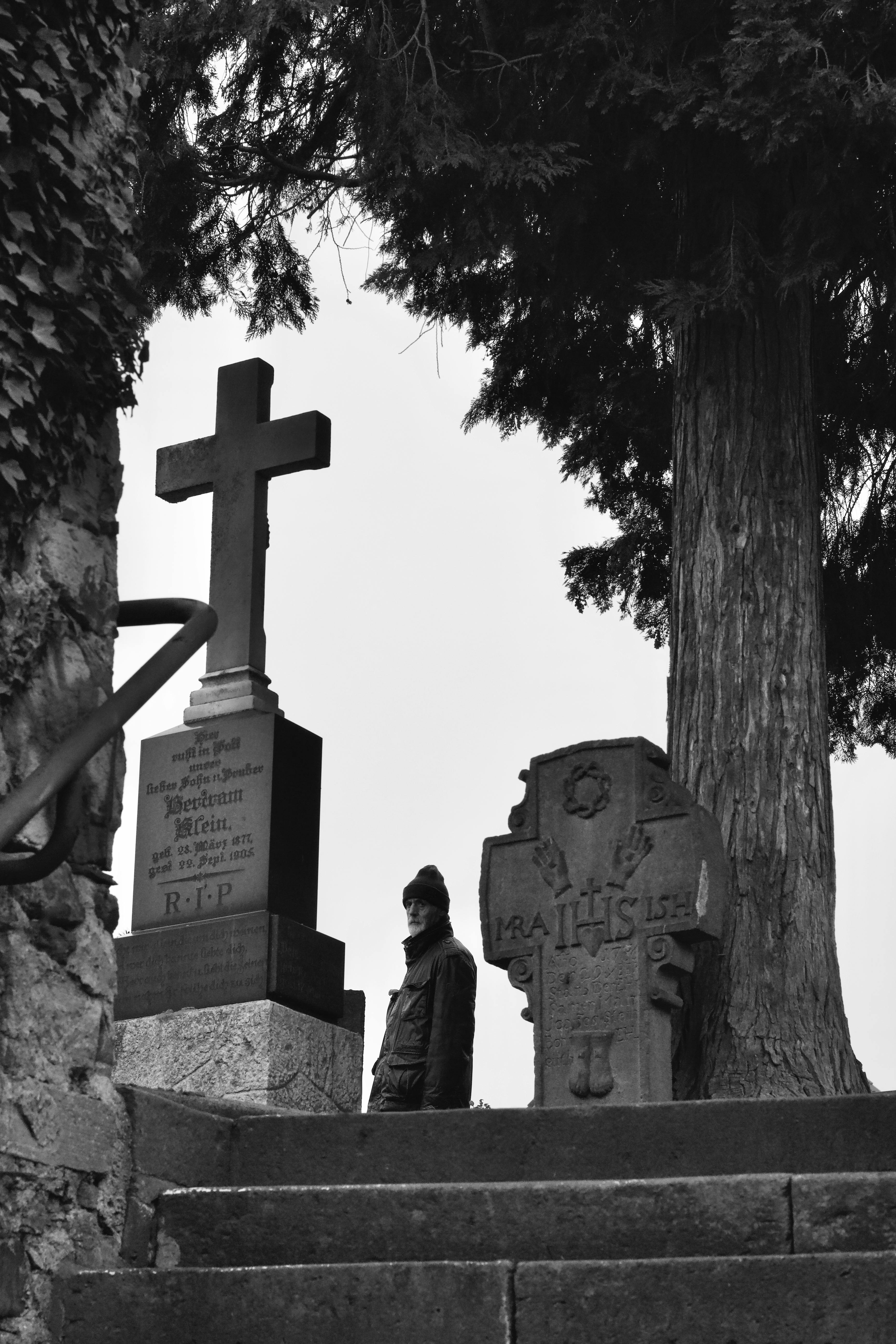 免費 一張莊嚴的黑白照片，展現了一座墓地，墓碑高聳醒目，還有一個巨大的十字架。 圖庫相片