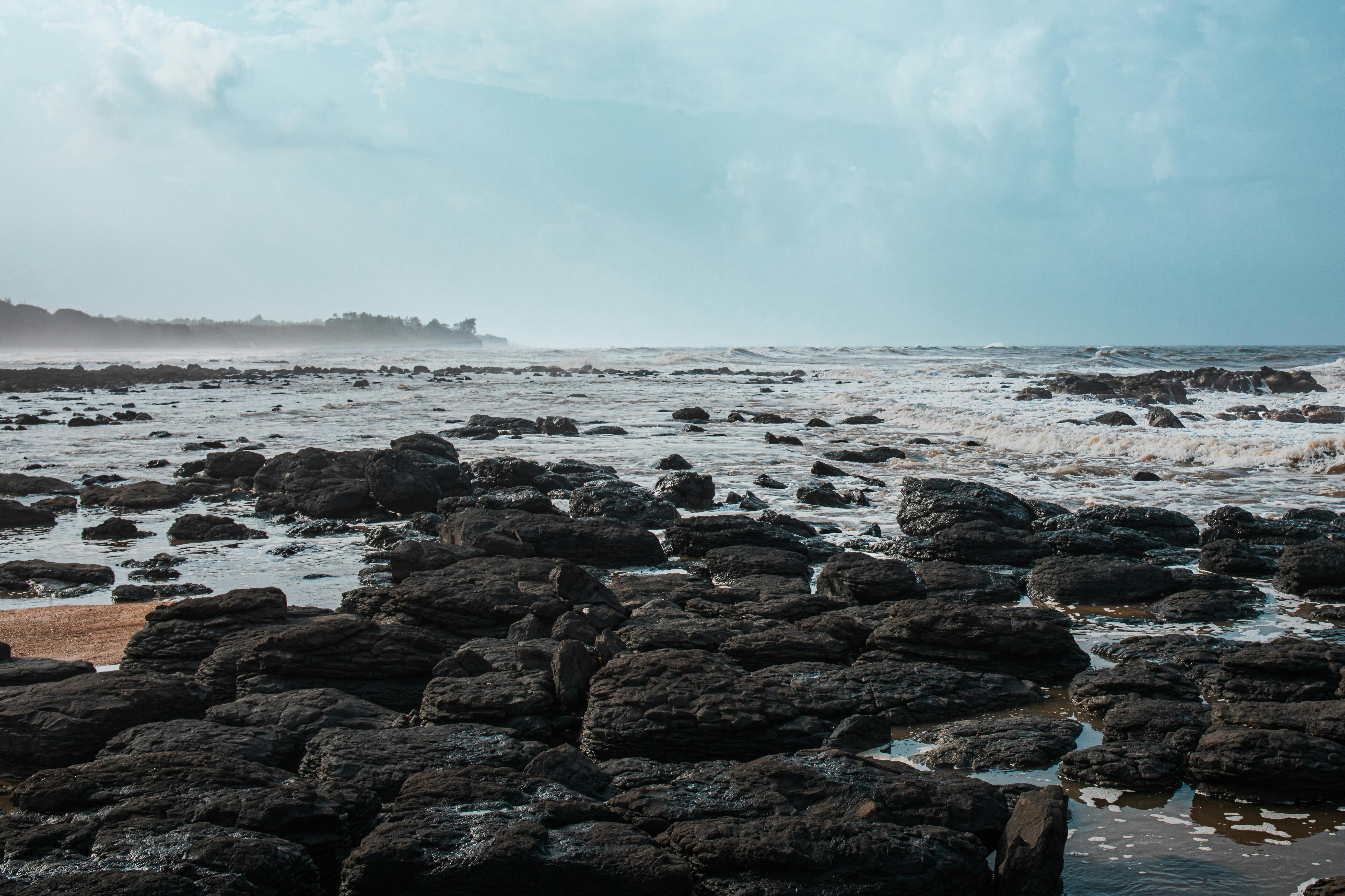 ฟรี ภาพทิวทัศน์อันงดงามของชายฝั่งหินขรุขระภายใต้ท้องฟ้าสีครามสดใส คลังภาพถ่าย