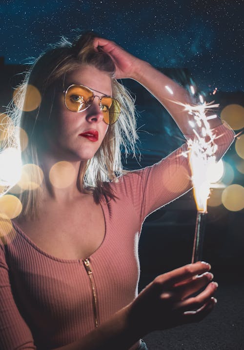 Woman Wearing Sunglasses Holding a Sparkler