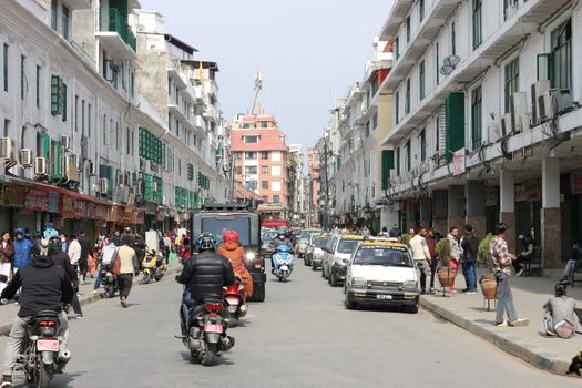 Vibrant street view of Kathmandu with local traffic, pedestrians, and urban architecture.