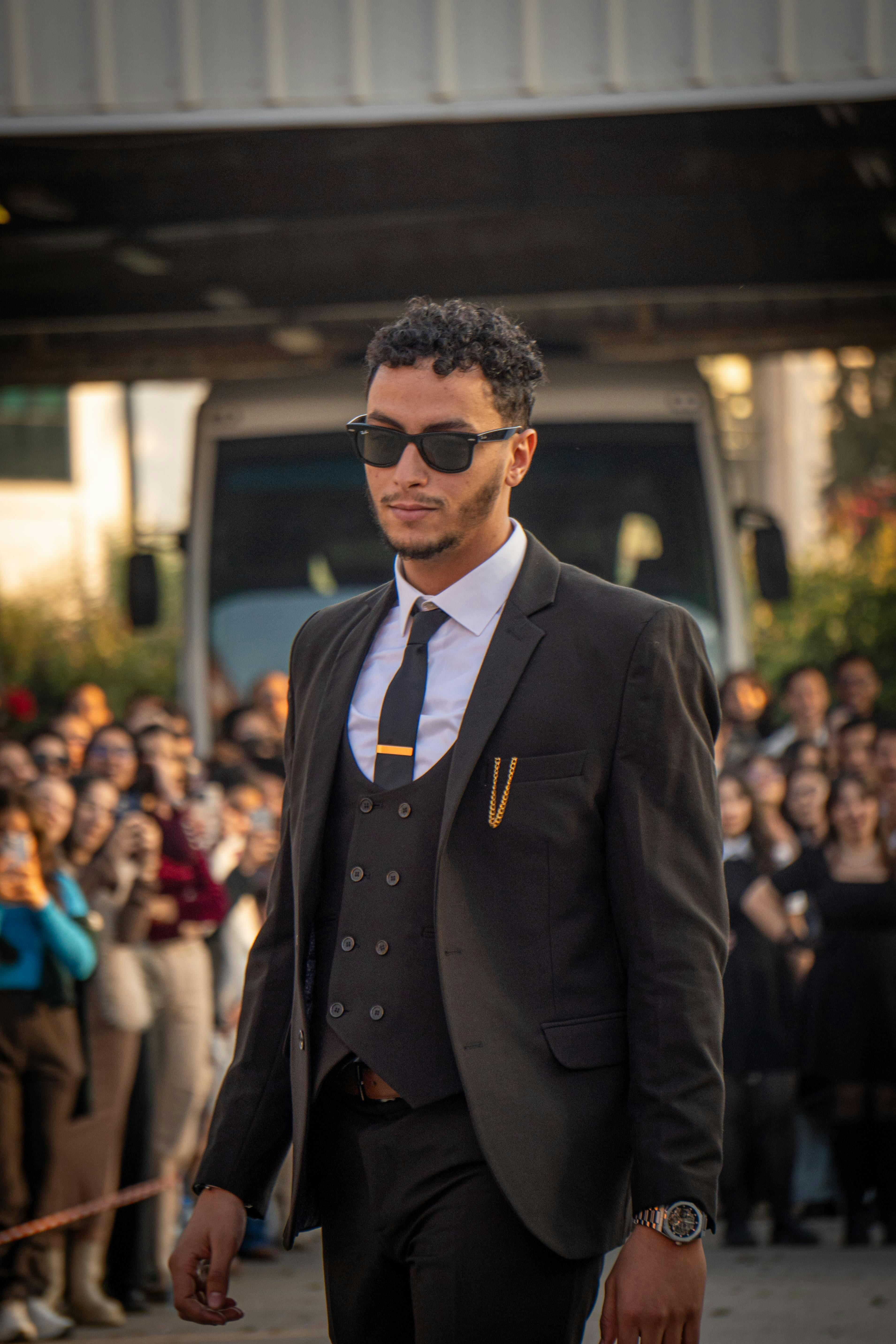 Zadarmo Sebavedomý muž v obleku sa elegantne prechádza na vonkajšom podujatí so štýlovými doplnkami. Fotka z fotobanky