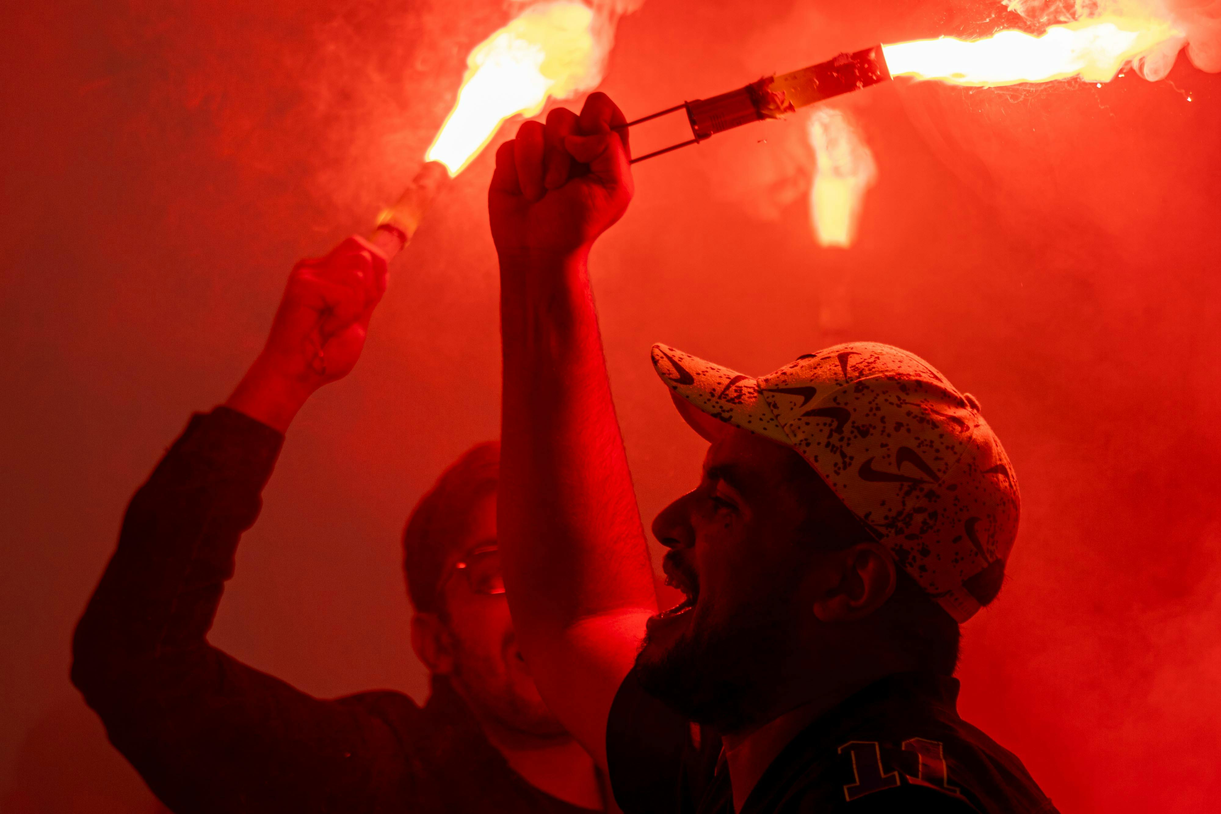 免費 兩名男子在夜間活動中燃放鮮紅色的焰火慶祝，營造出熱烈的氣氛。 圖庫相片