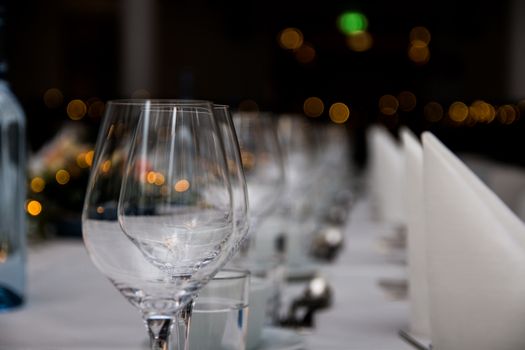 Close-up of sparkling wine glasses elegantly arranged on a formal dining table, creating a warm and inviting atmosphere.