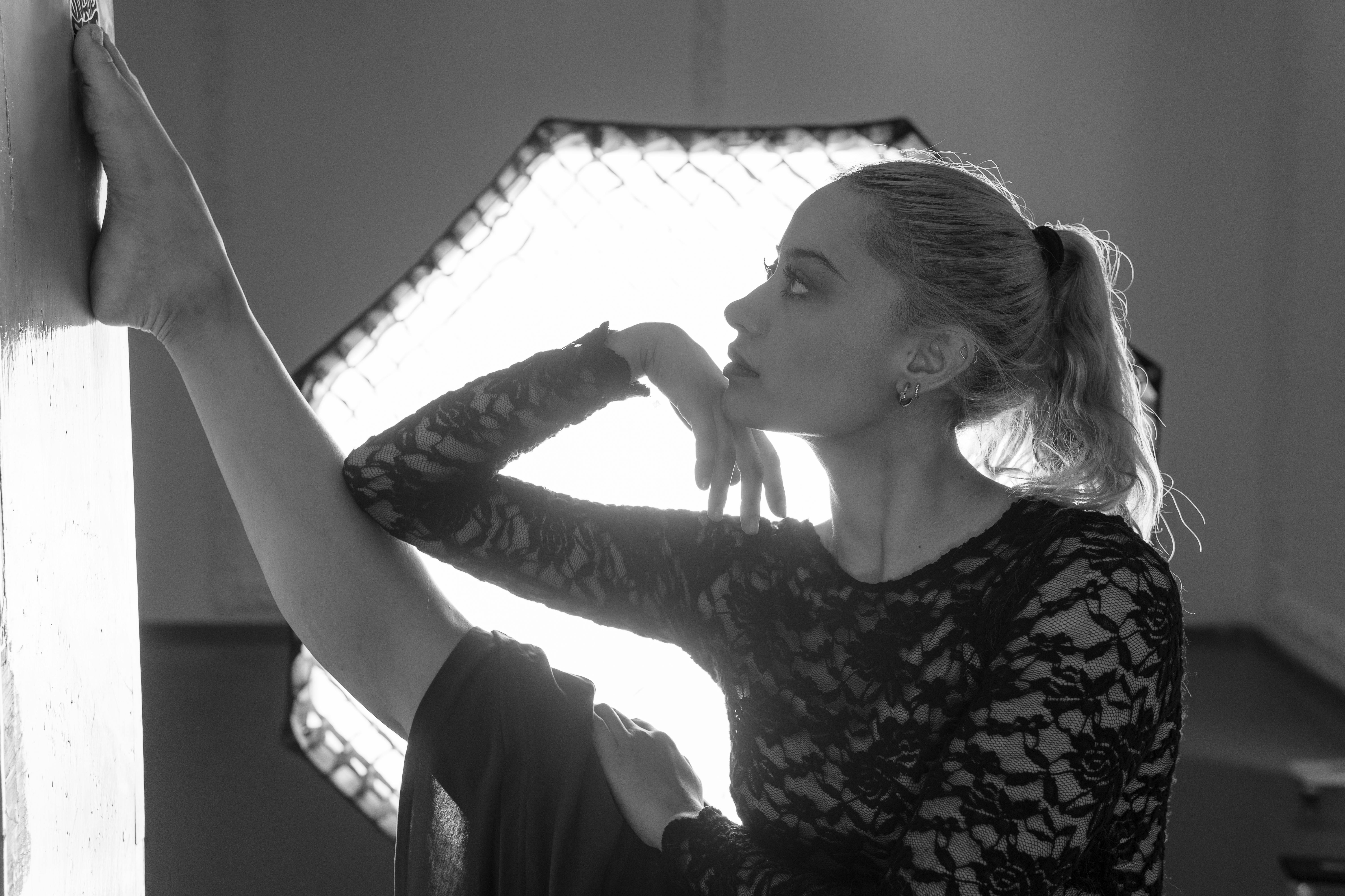 Безкоштовне Чорно-білий портрет танцівниці, яка граціозно розтягується в приміщенні. стокове фото