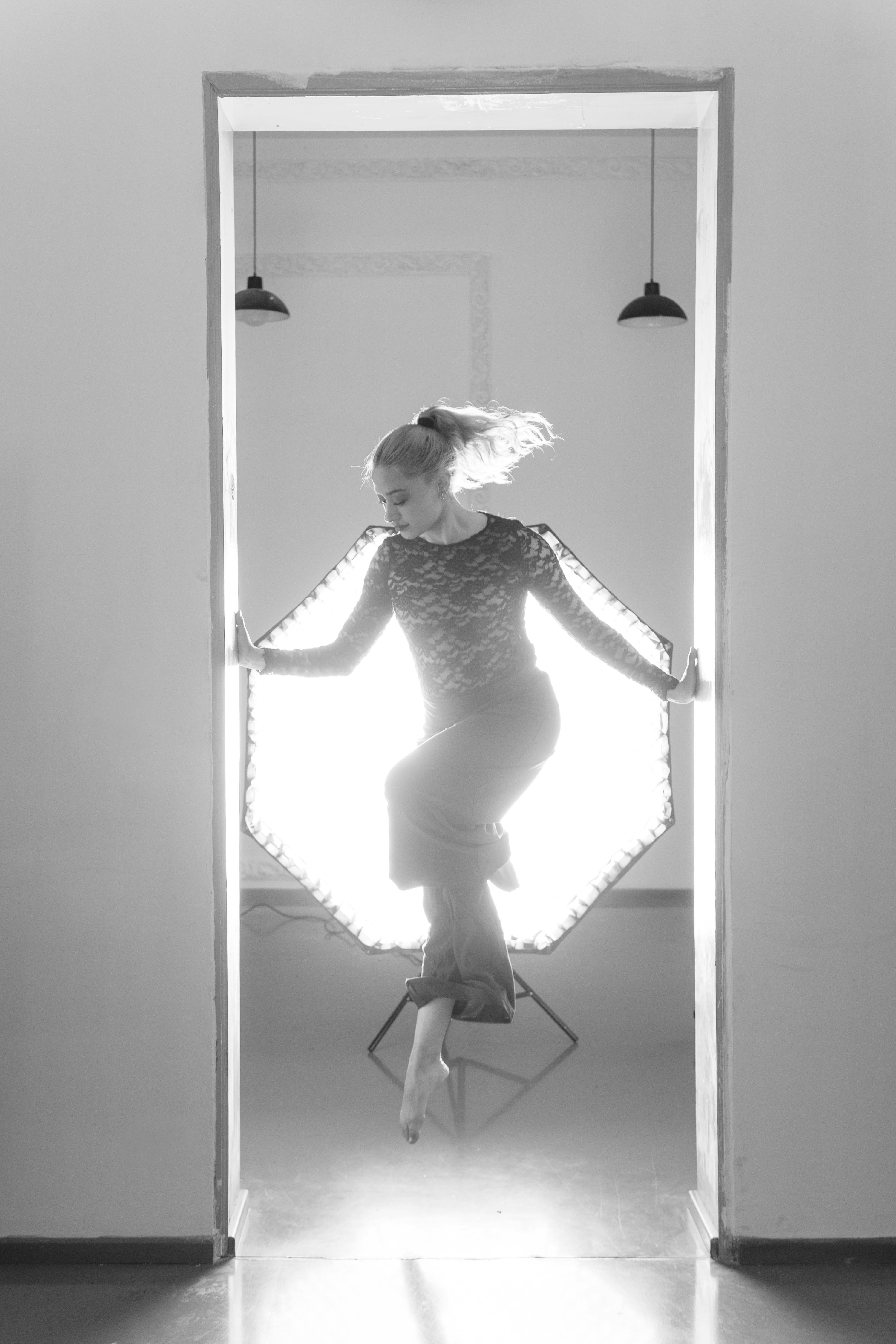 免費 黑白肖像照，拍攝對像是一位現代舞女，她擺出騰空的姿勢，拍攝於室內，光線極具戲劇性。 圖庫相片