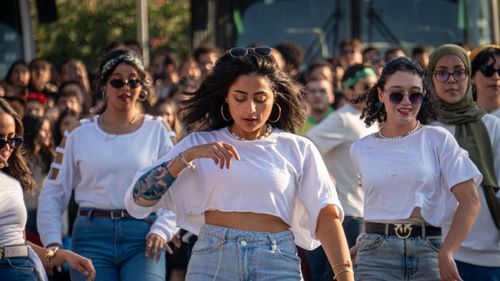 Free A vibrant crowd of young adults dancing outdoors during a lively street event. Stock Photo