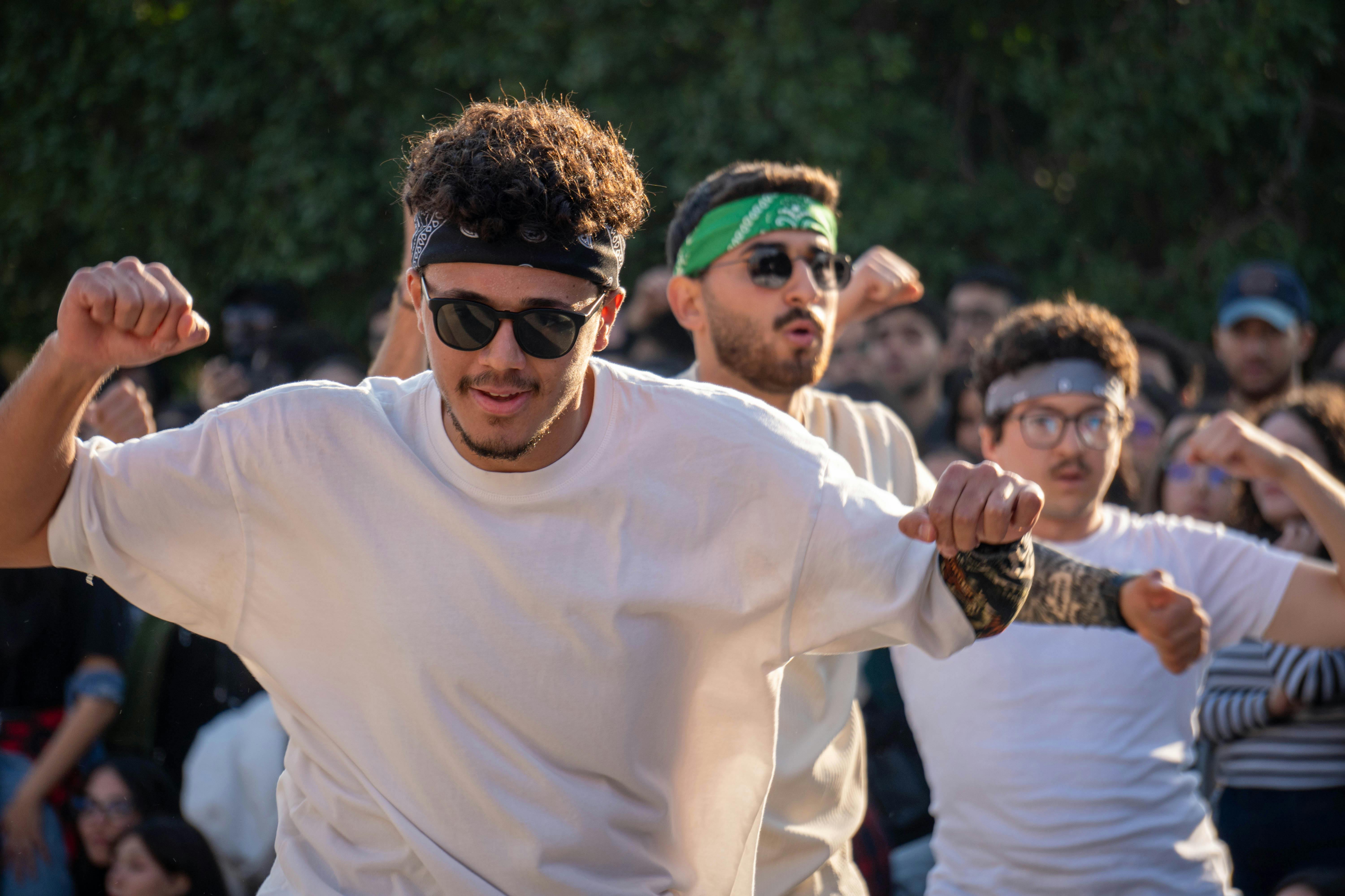 Zadarmo Dynamická skupina mladých mužov, ktorí štýlovo a energicky predvádzajú temperamentný tanec vonku. Fotka z fotobanky