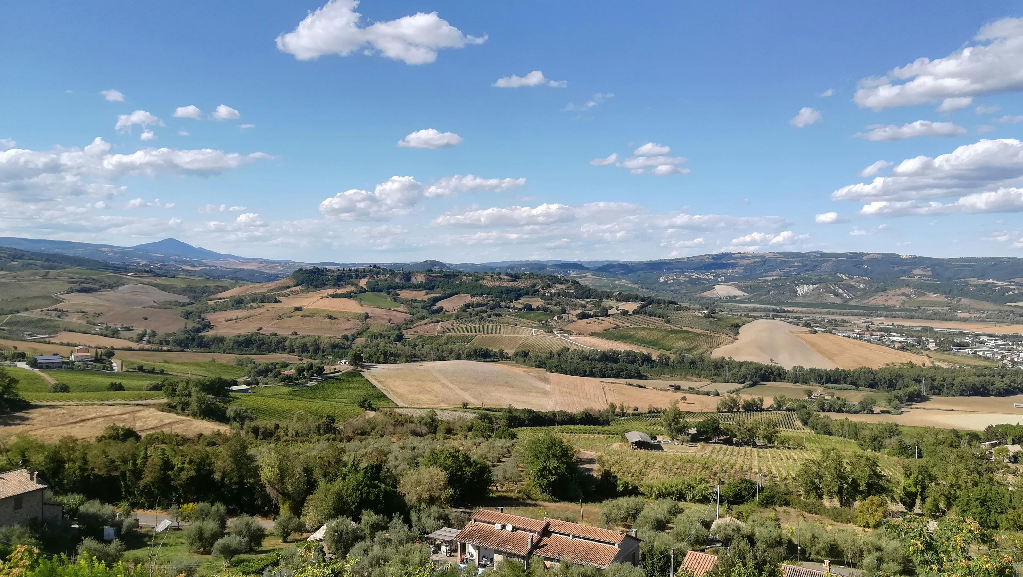 bezplatná Krásný výhled na zvlněné kopce a pole italské krajiny pod modrou oblohou. Základová fotografie