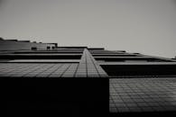 从低角度拍摄的黑白现代摩天大楼，突显了建筑线条与透视效果