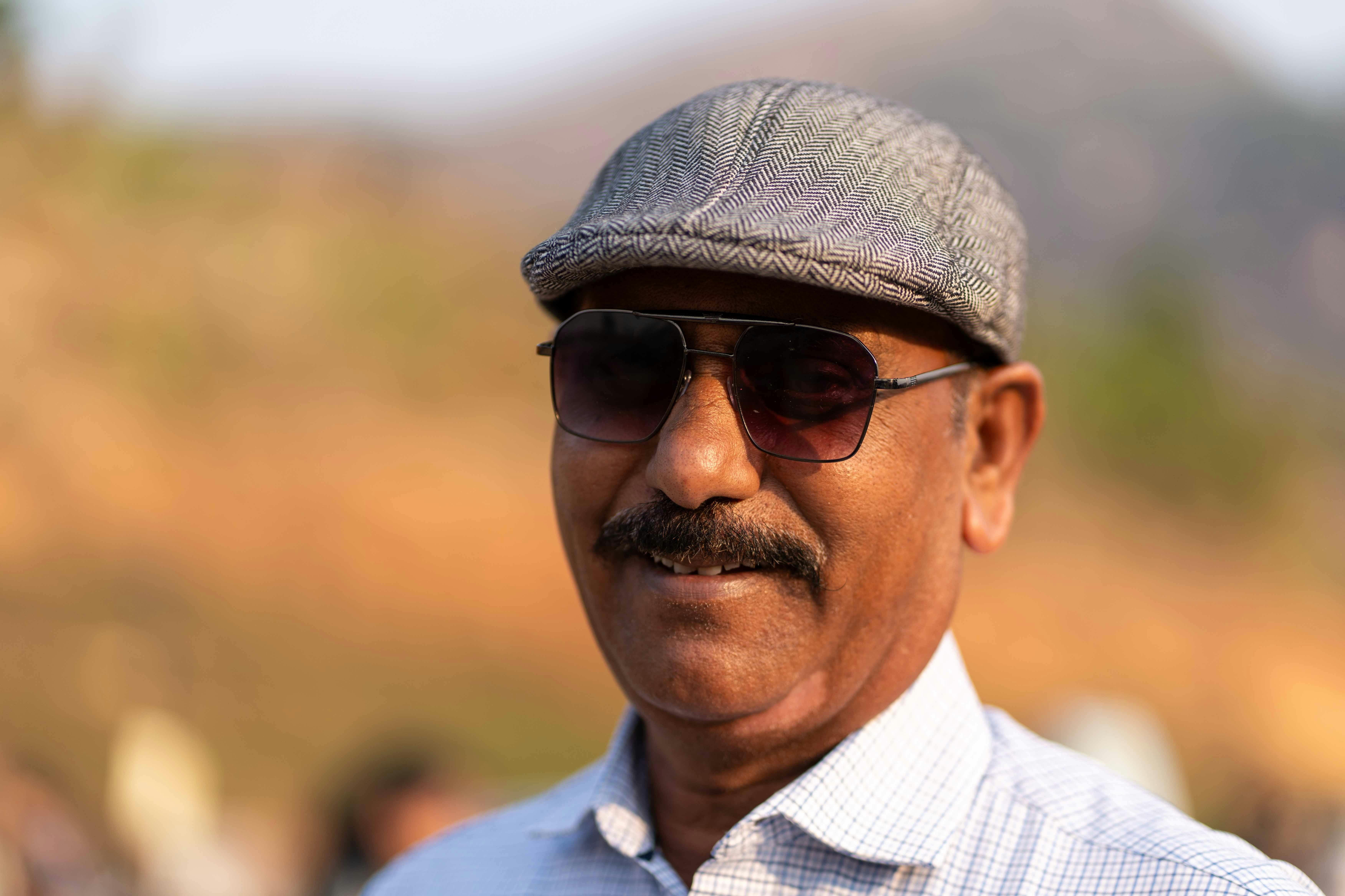 Безкоштовне Портрет усміхненого чоловіка в сонцезахисних окулярах і кепці на сонячному відкритому повітрі. стокове фото