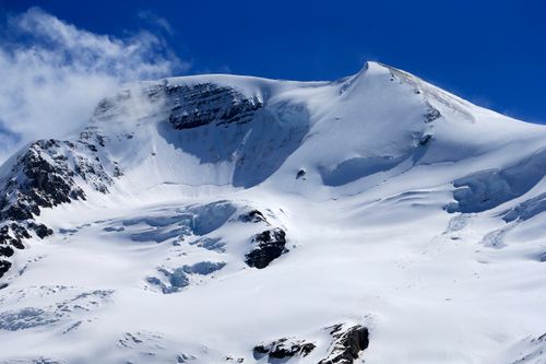 Free Stunning view of a snow-covered mountain peak with clear blue sky in winter. Stock Photo