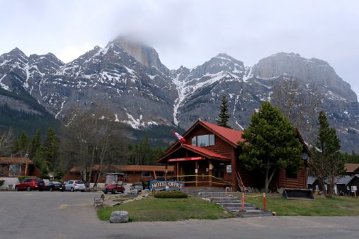Mountain lodge with snowy peaks in the background, offering a rustic getaway vibe.
