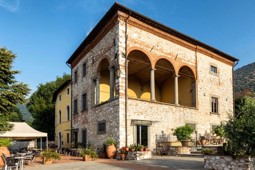 A charming stone villa in Tuscany showcasing classic Italian architecture bathed in sunlight.