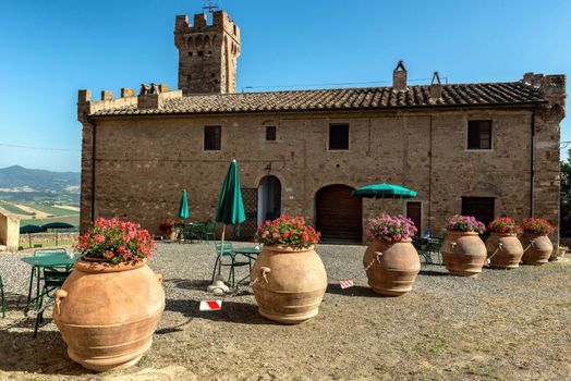 Beautiful rustic villa in Tuscany's countryside with terracotta pots and rural charm.