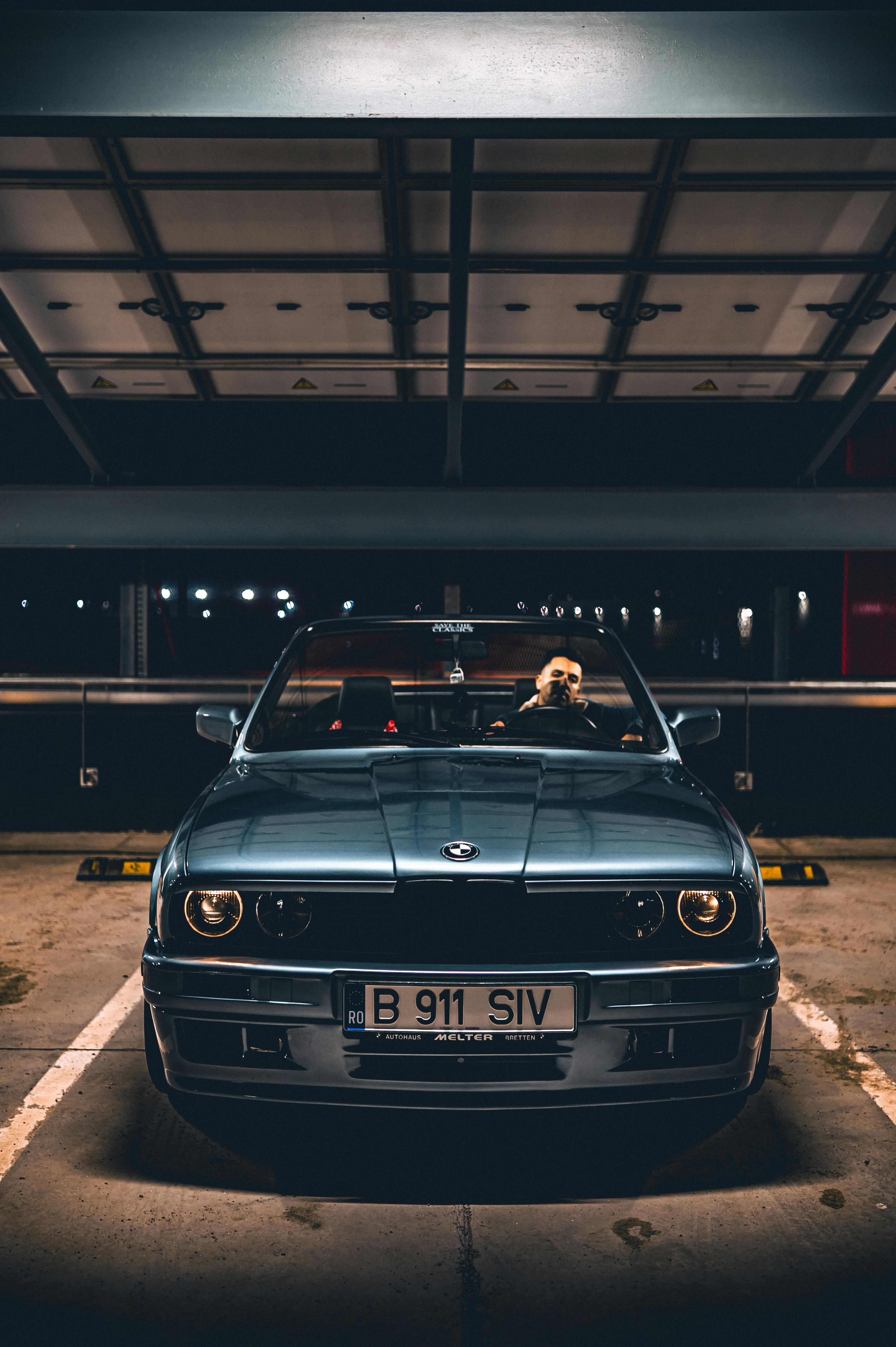 무료 도심 주차장에 밤에 주차된 클래식 컨버터블 자동차. 스톡 사진