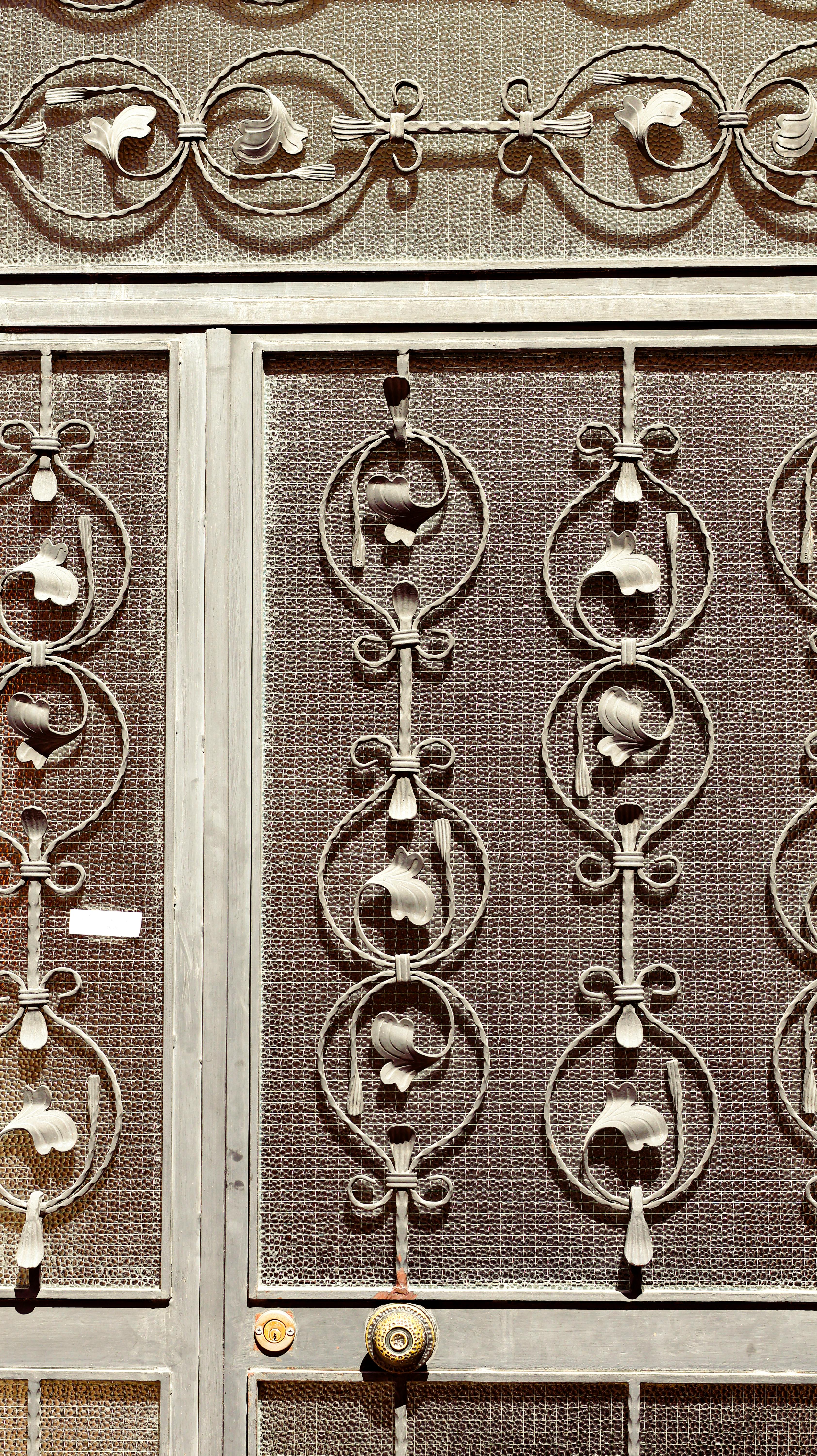 Zadarmo Detailný záber na ozdobnú kovovú bránu so zložitými vzormi, ktoré zdôrazňujú remeselné spracovanie. Fotka z fotobanky