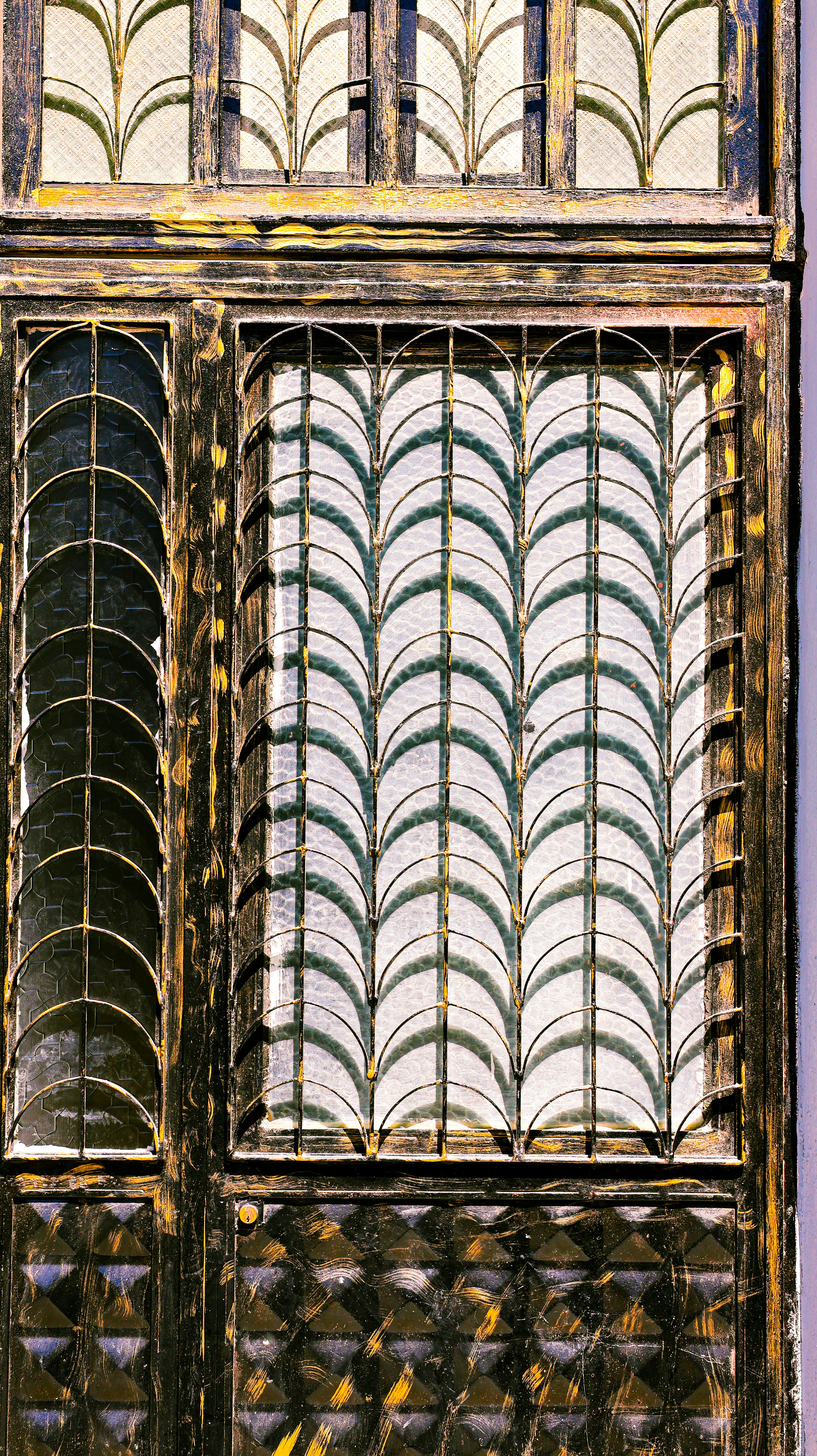 Zadarmo Detailný pohľad na starožitnú železnú bránu s prepracovaným kovovým spracovaním a vzorovaným sklom. Fotka z fotobanky