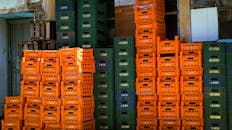 Stacked Orange and Green Plastic Crates Outdoors