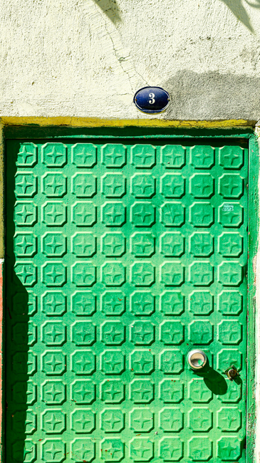 Fotomural Puerta verde vibrante con patrones geométricos y el número 3 en la parte superior.