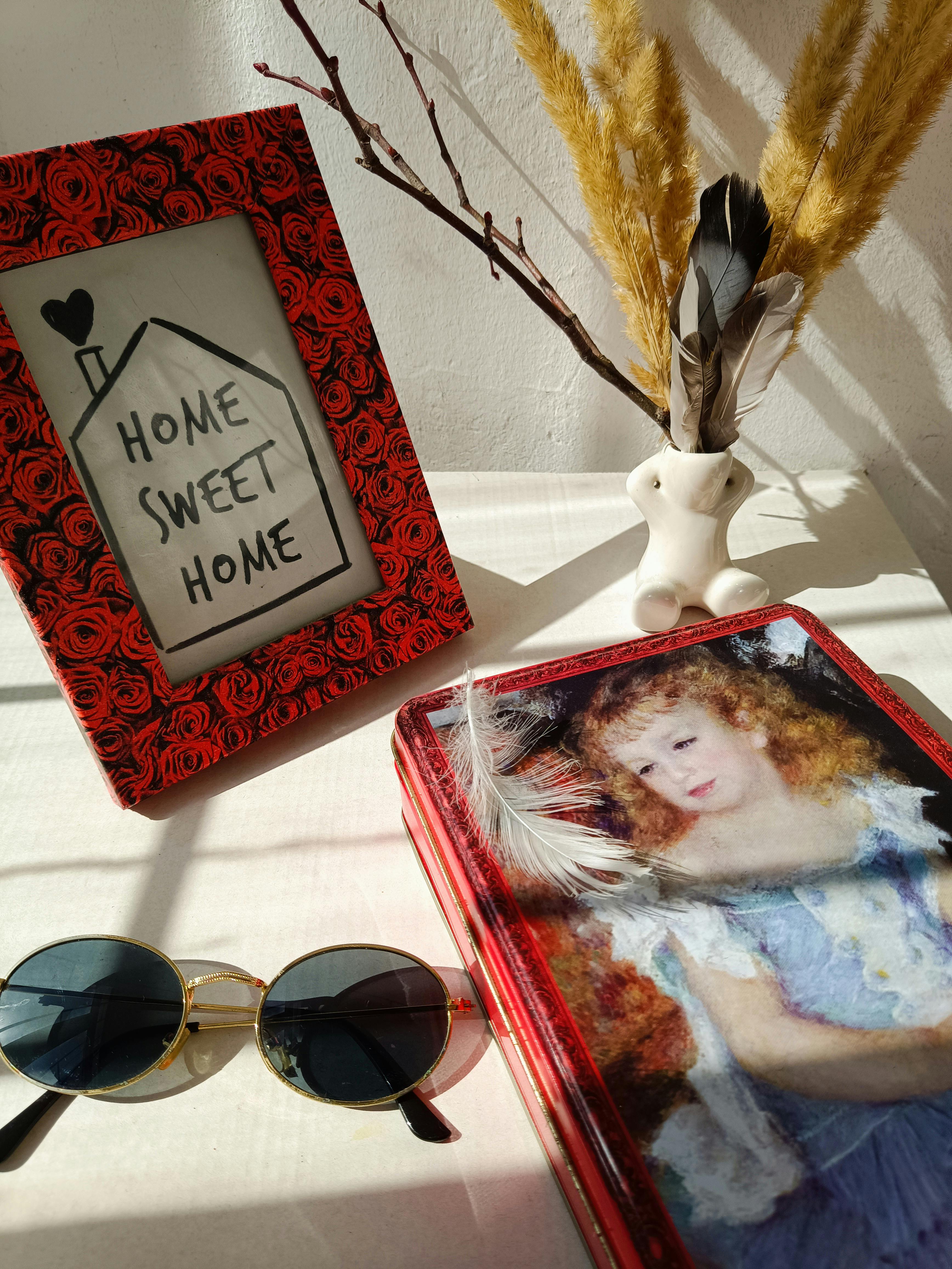 免費 一幅生動的靜物畫，在藝術化的燈光下，展現了相框、書籍和太陽眼鏡。 圖庫相片