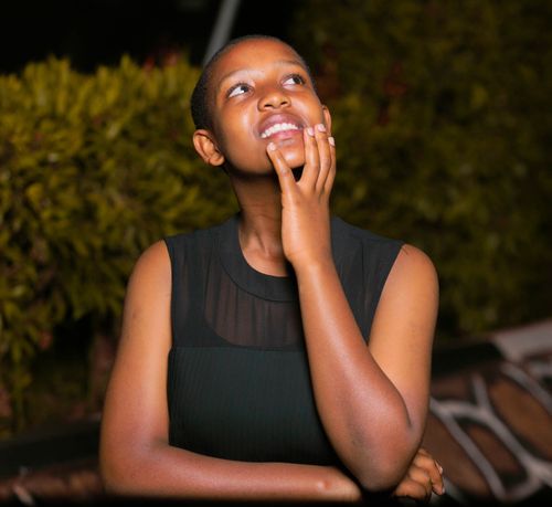 Free A young woman in a thoughtful pose outdoors at night with a serene expression. Stock Photo