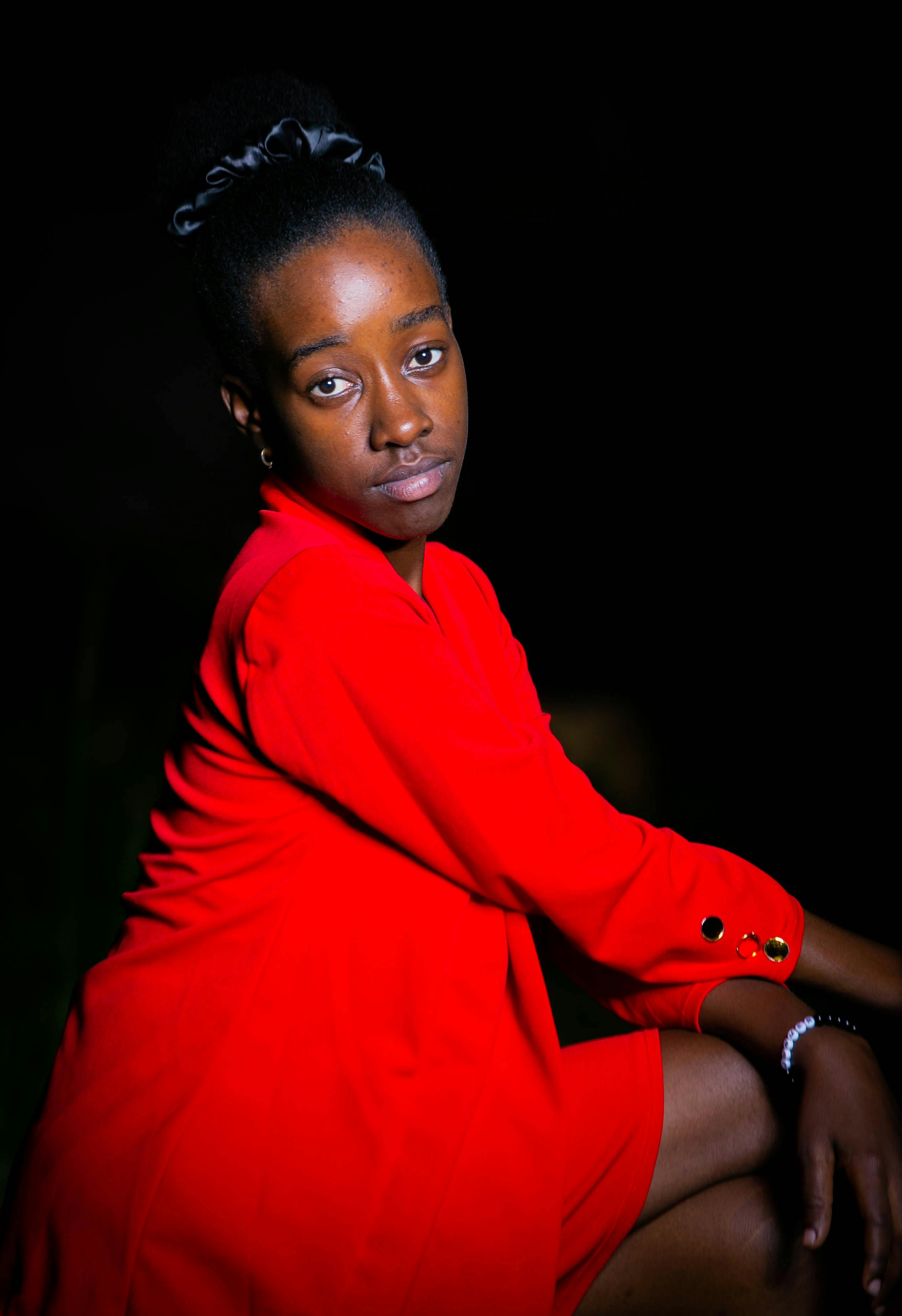 免費 一位自信的女子穿著紅色連身裙，在夜色中擺出優雅的姿勢。 圖庫相片