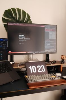 A modern home office setup with PC, monitor, keyboard, and clock display.