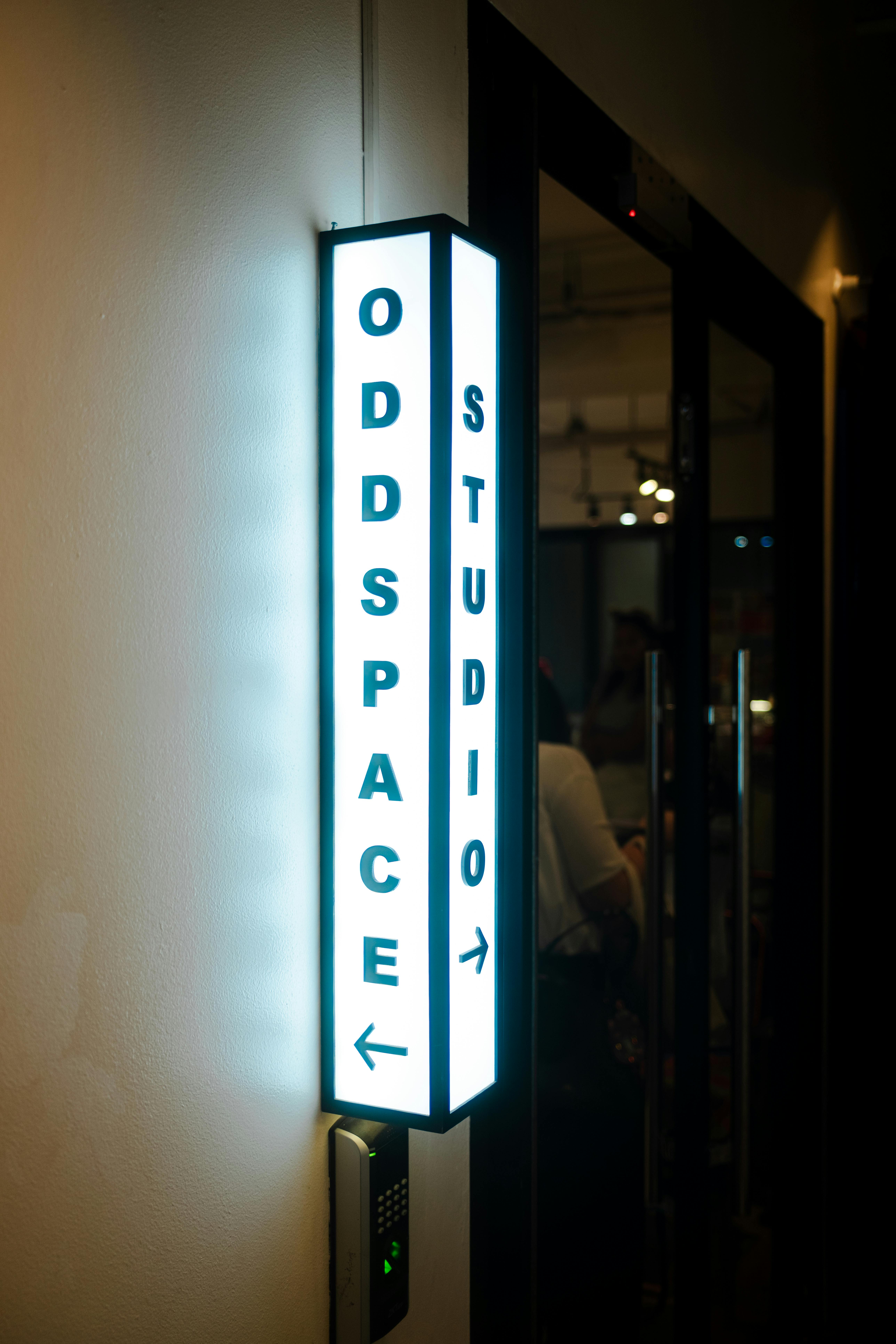 Безкоштовне Яскрава вивіска Oddspace Studio підкреслює вхід, знятий у приміщенні. стокове фото