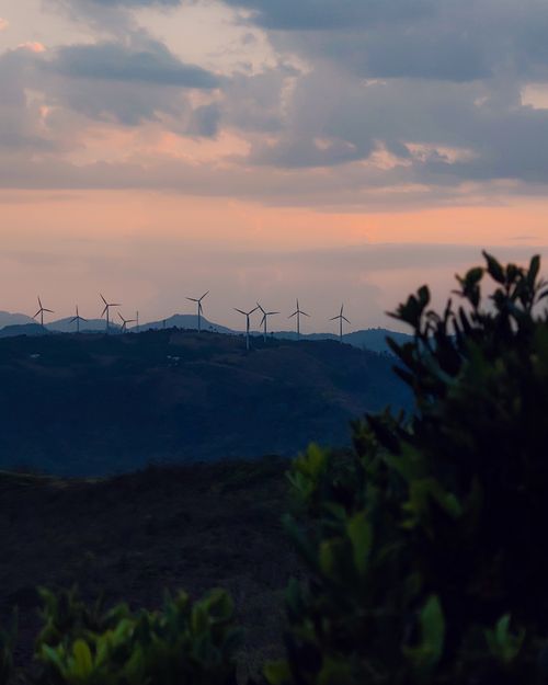 Free Scenic sunset landscape with wind turbines atop a mountain ridge. Stock Photo