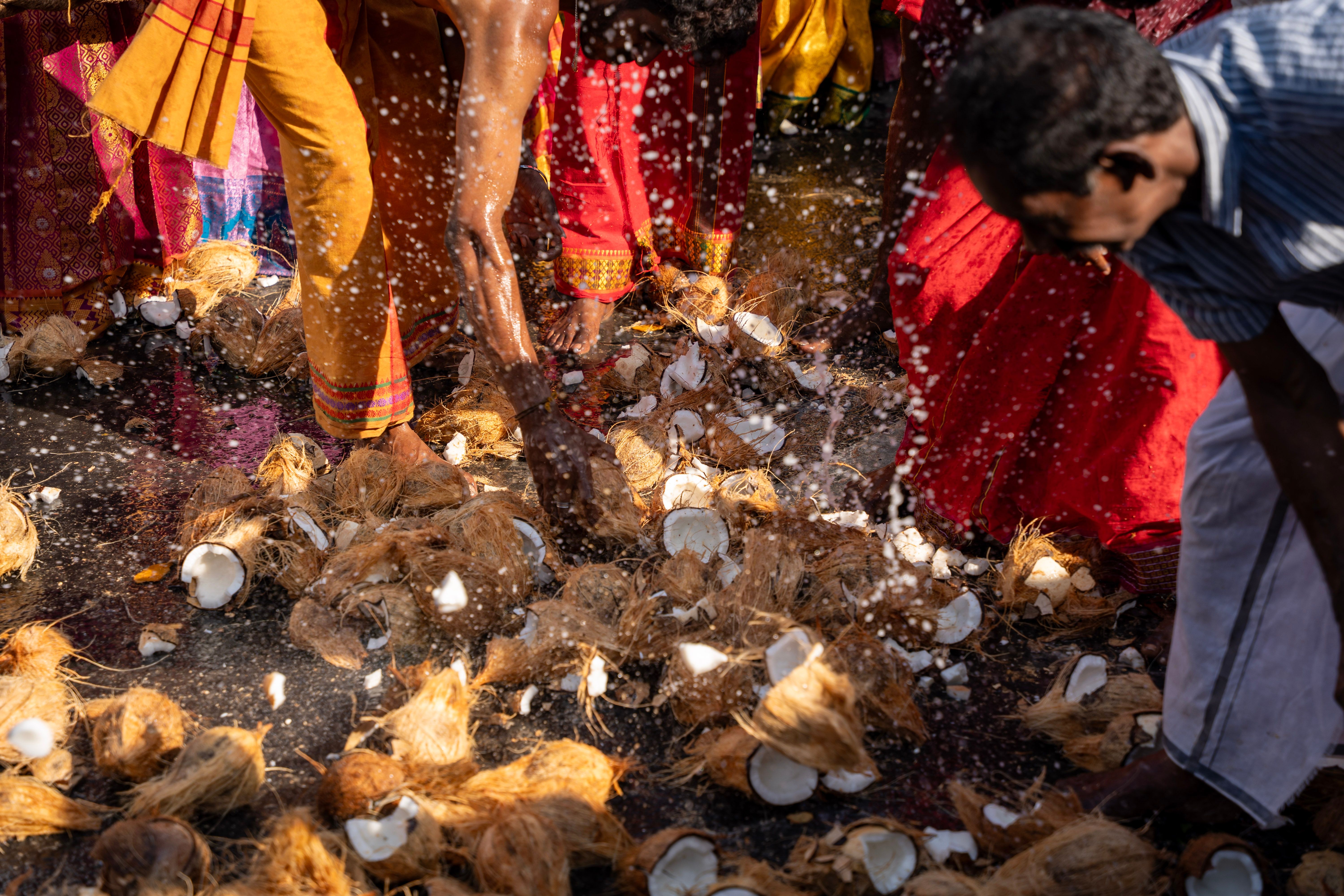 Colorful scene of people participating in coconut-breaking ritual at a Hindu festival. — Trójmiasto