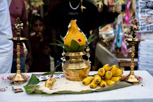 A vibrant setup for a Hindu ritual with traditional brass items, fruits, and decorative elements.
