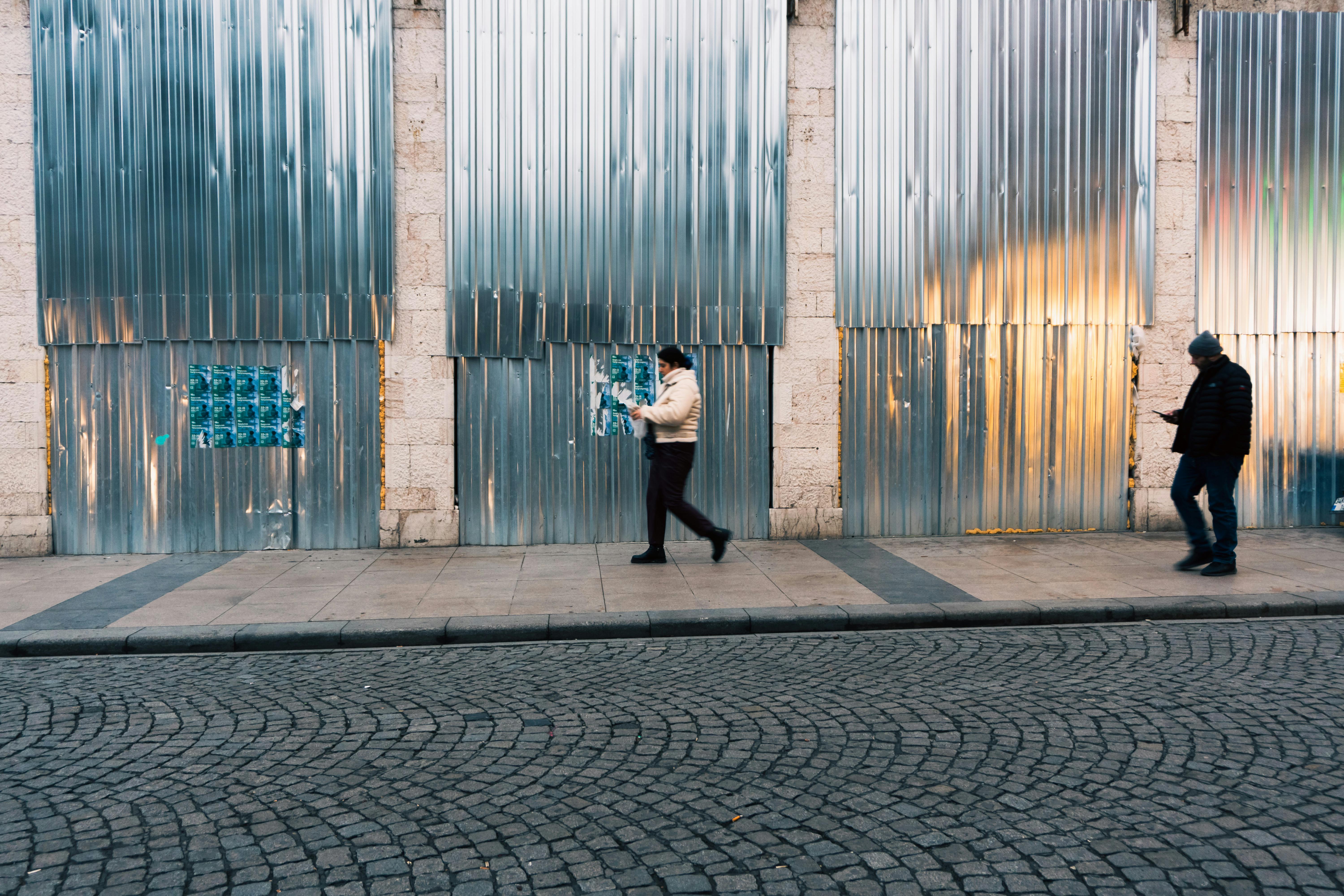 ingyenes Két gyalogos sétál egy fémburkolatú utcán Isztambulban, Törökországban, egy nappal. Stockfotó