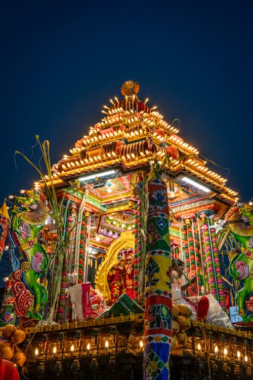 Free Brightly lit temple chariot adorned with colorful decorations during a night festival. Stock Photo