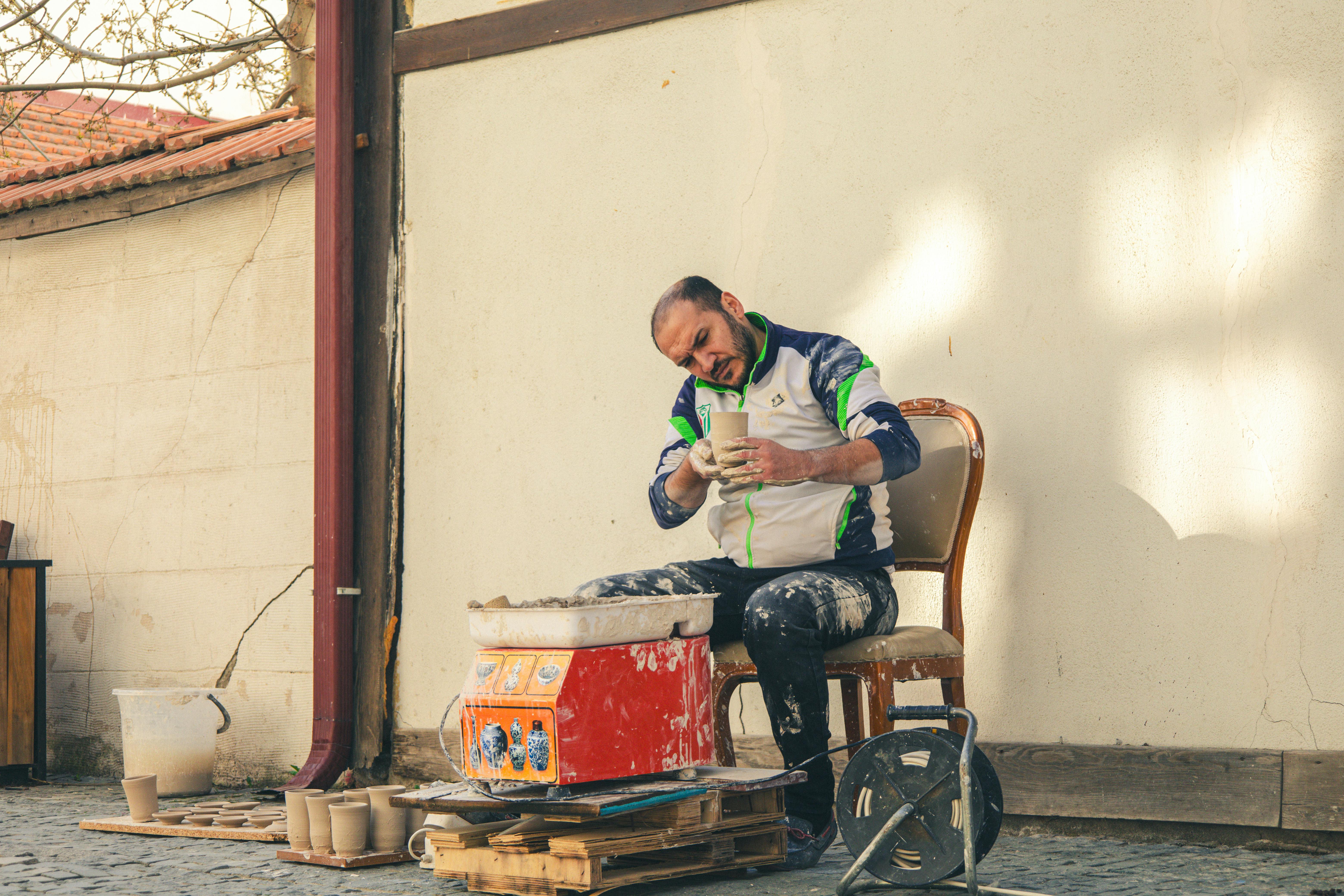 ฟรี ช่างปั้นดินเผากำลังปั้นเครื่องปั้นดินเผาอย่างชำนาญในสตูดิโอกลางแจ้งในเมืองคูตาห์ยา ประเทศตุรกี คลังภาพถ่าย