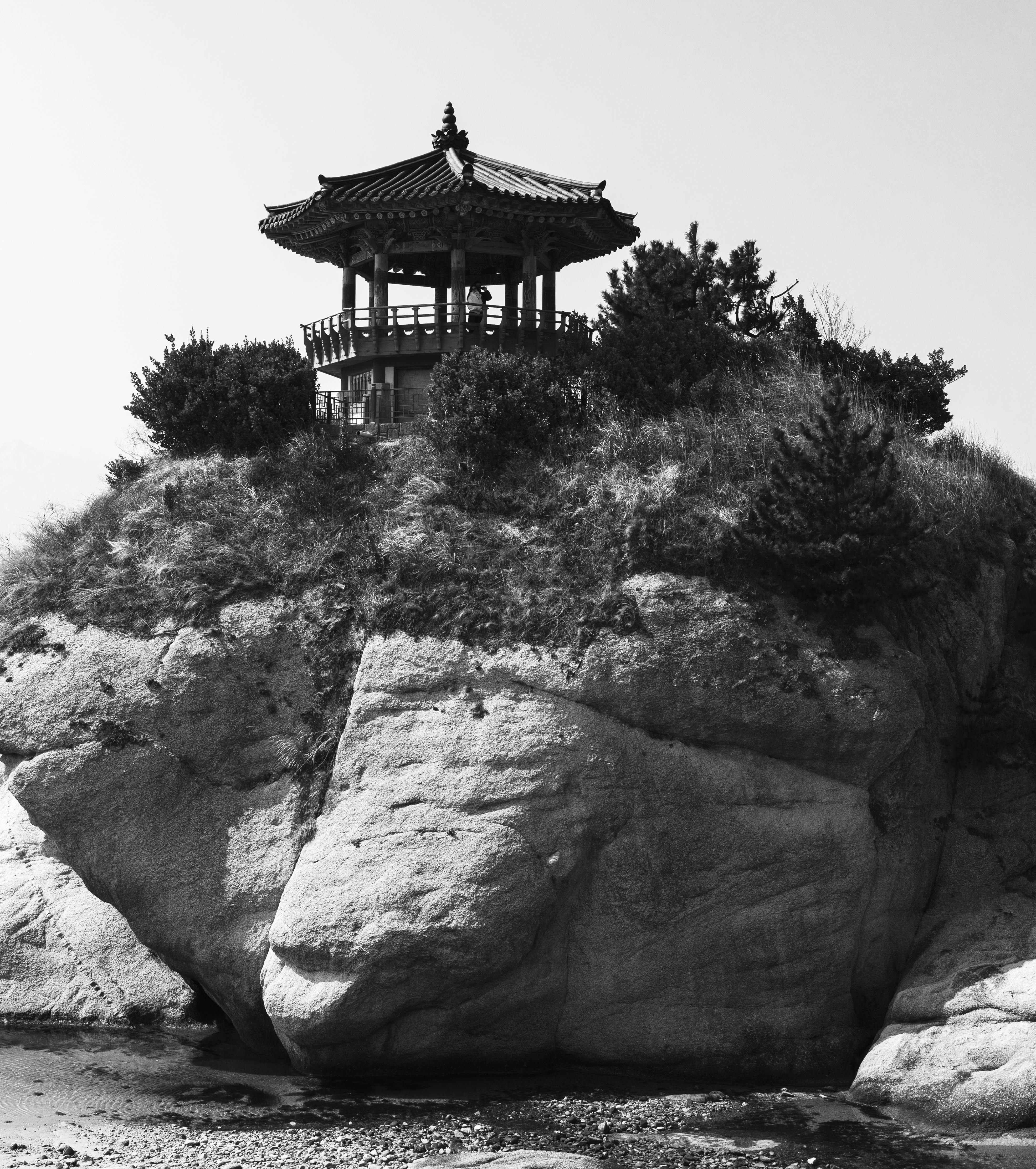 免费 一座经典的亭子坐落在岩石峭壁之上，照片以醒目的黑白风格呈现。 素材图片