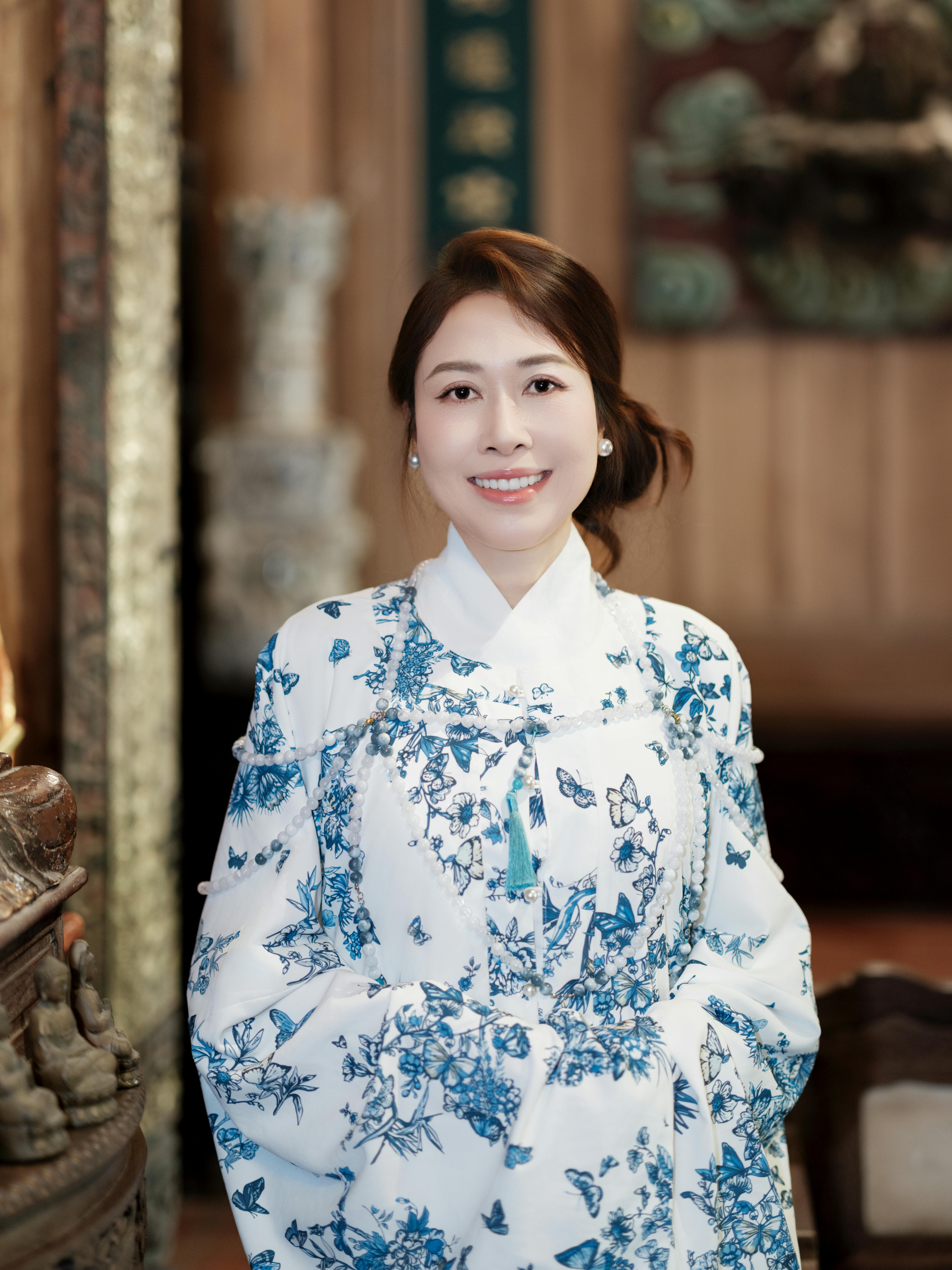 Elegant portrait of a woman in beautiful traditional hanbok, smiling indoors.