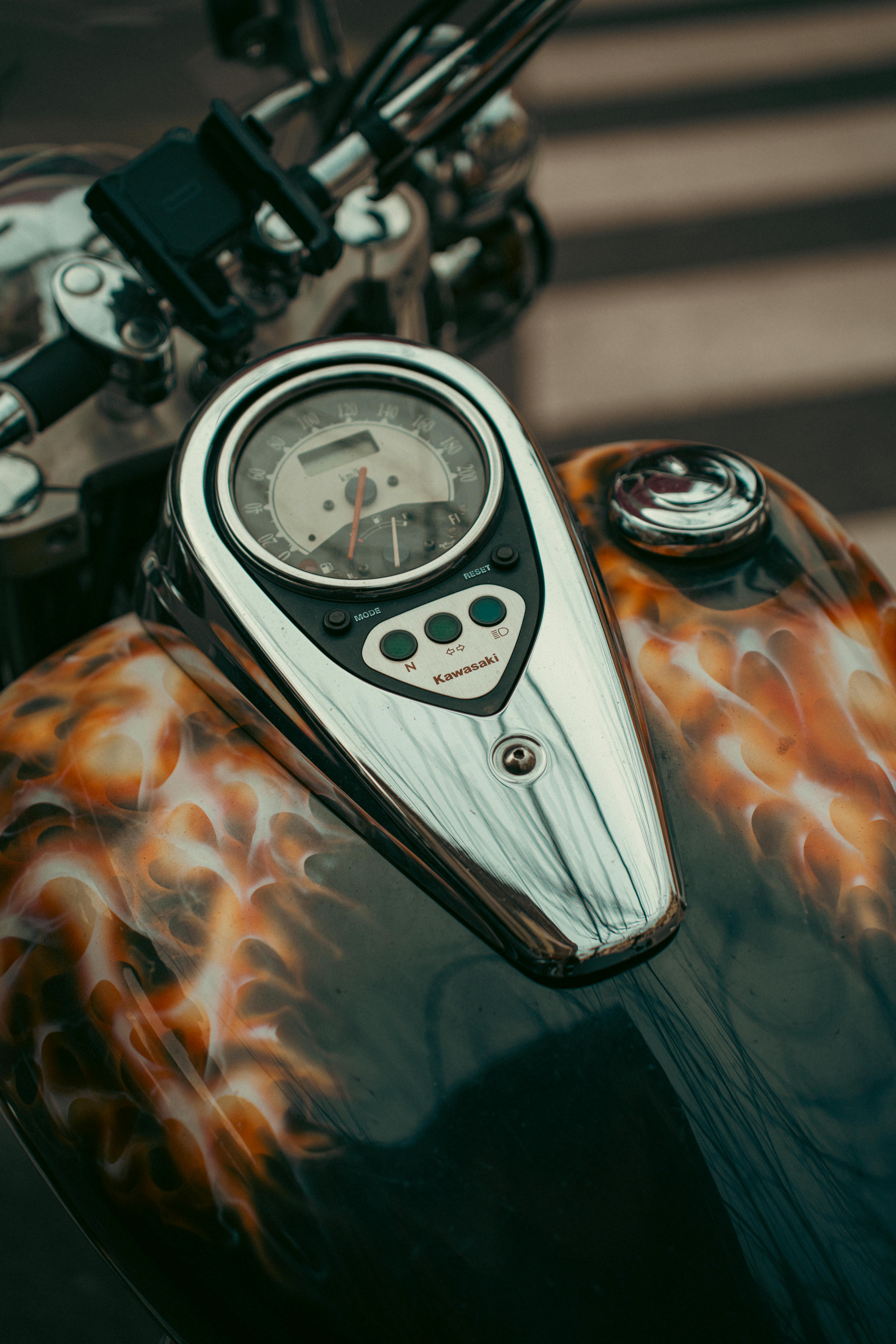 ingyenes Egy motorkerékpár üzemanyagtartályának művészi közeli felvétele lángdizájnnal, amelyen egyedi airbrush munkák láthatók. Stockfotó