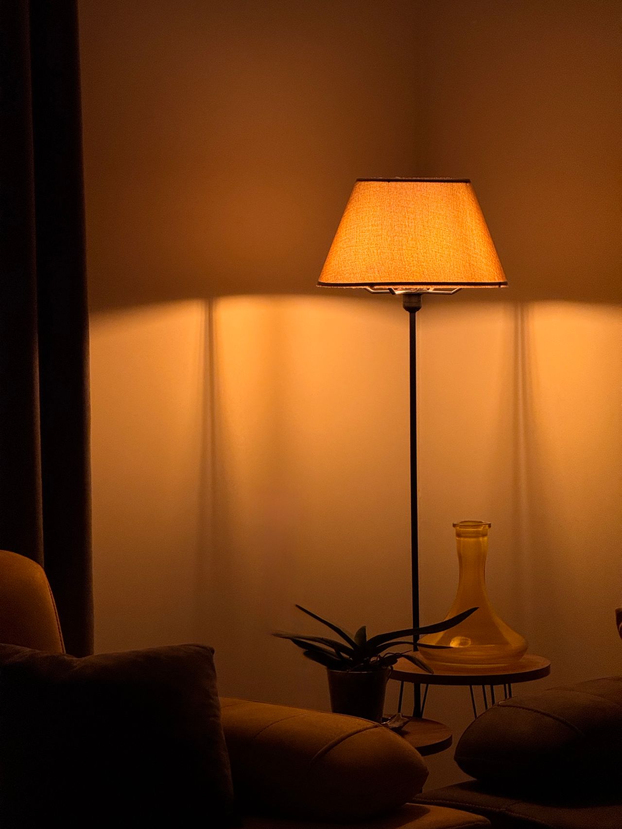 Warm glowing floor lamp lighting a dark living room corner