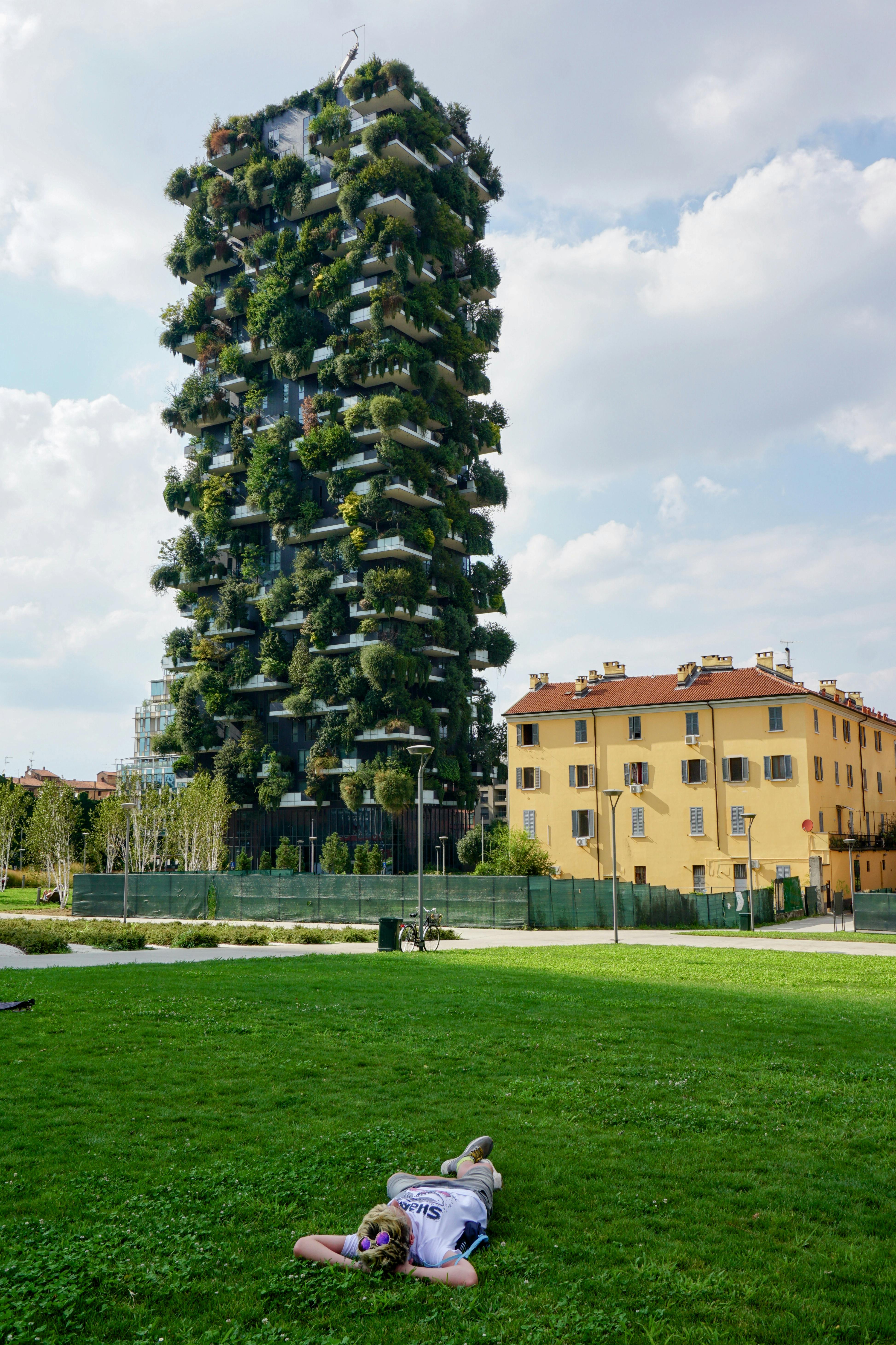 Zadarmo Muž relaxuje na trávniku pred mrakodrapom Bosco Verticale, ikonickou zelenou architektúrou Milána. Fotka z fotobanky