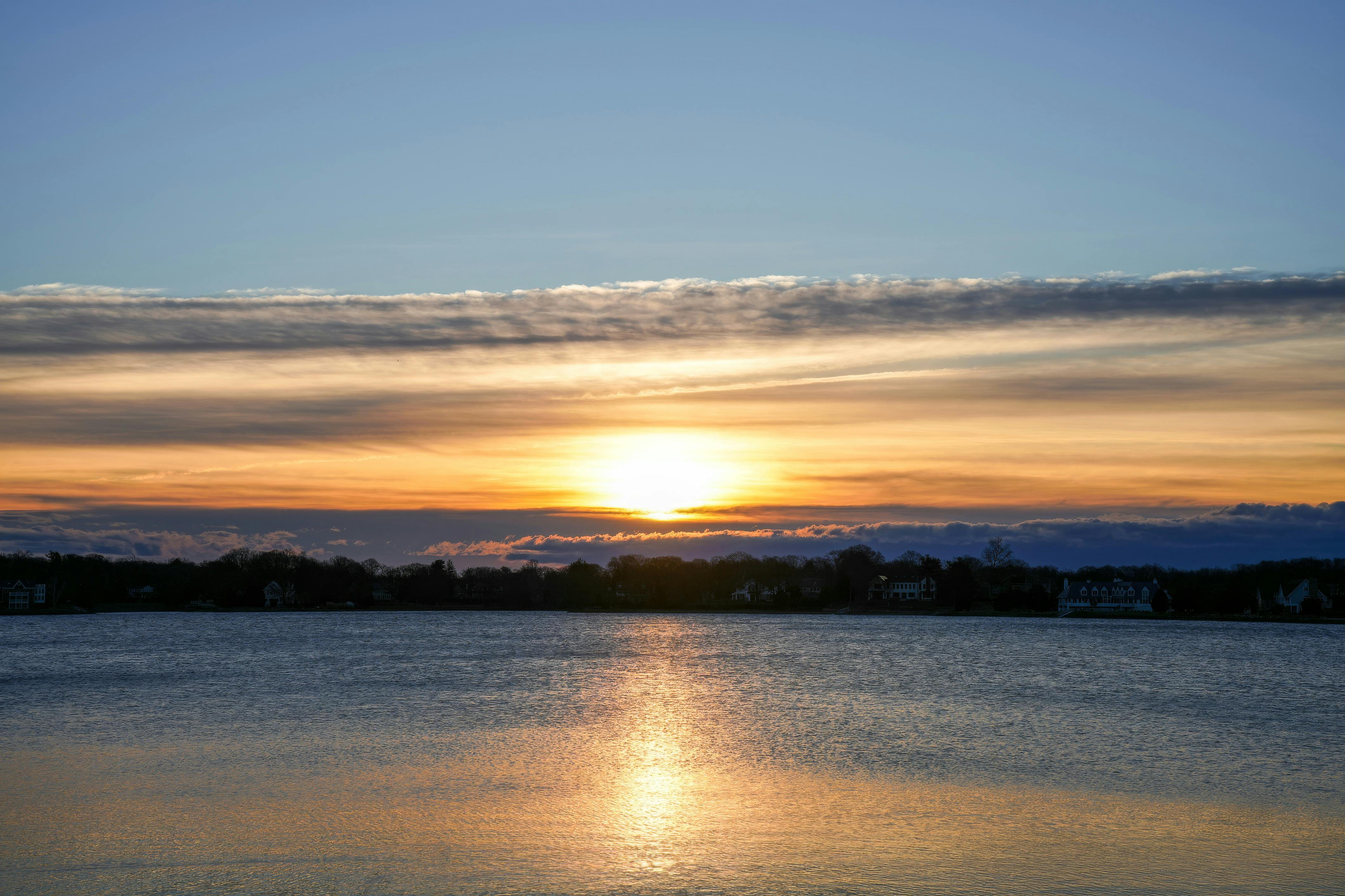 免费 捕捉到宁静的湖面上日出的美景，绚丽的天空色彩倒映在湖面上。 素材图片