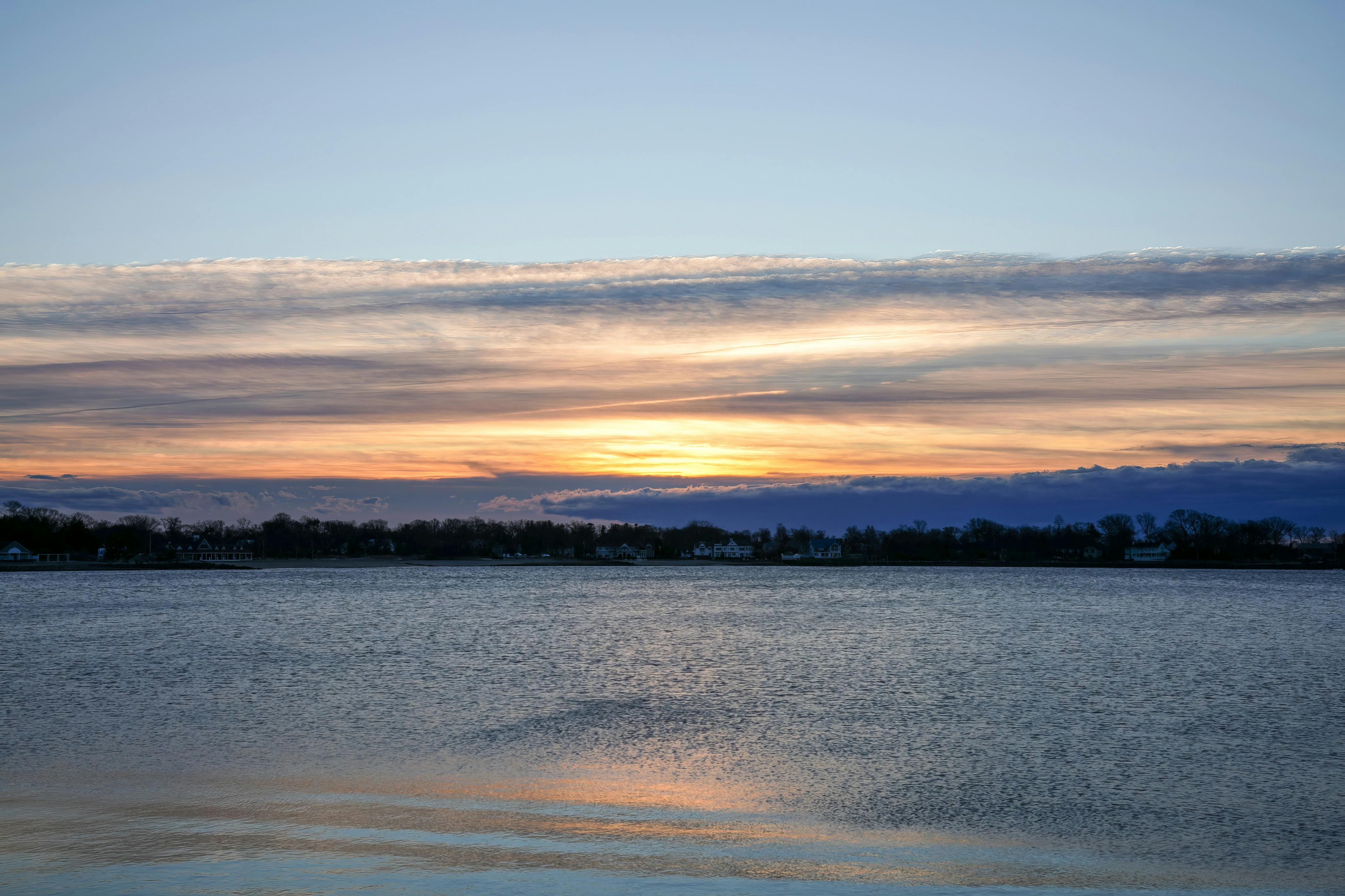 Zadarmo Pokojná súmraková scenéria s pokojným jazerom a žiarivými odrazmi oblohy. Fotka z fotobanky