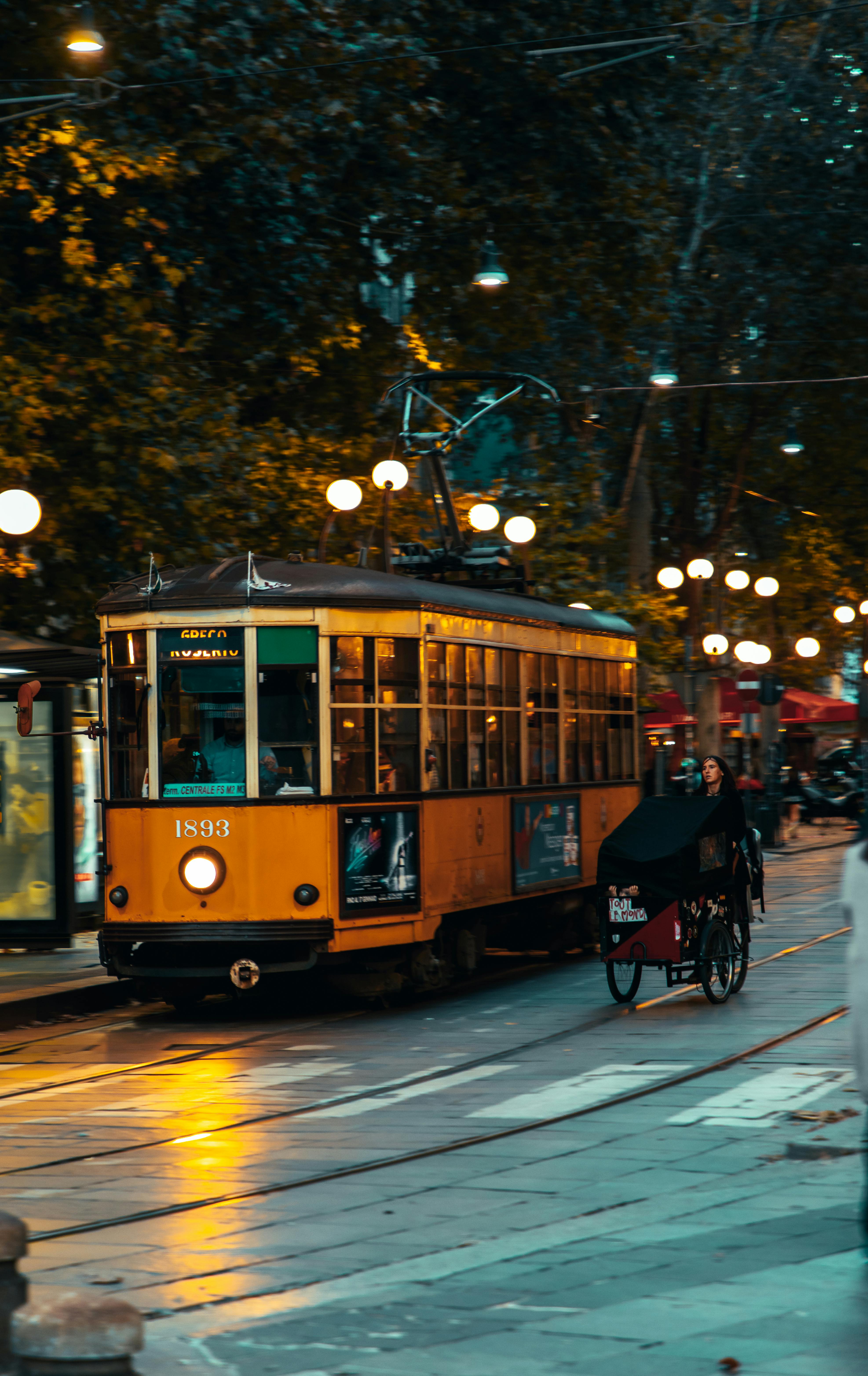 ingyenes Egy vintage sárga villamos száguld végig a kivilágított városi utcákon este, megragadva a városi bájt. Stockfotó