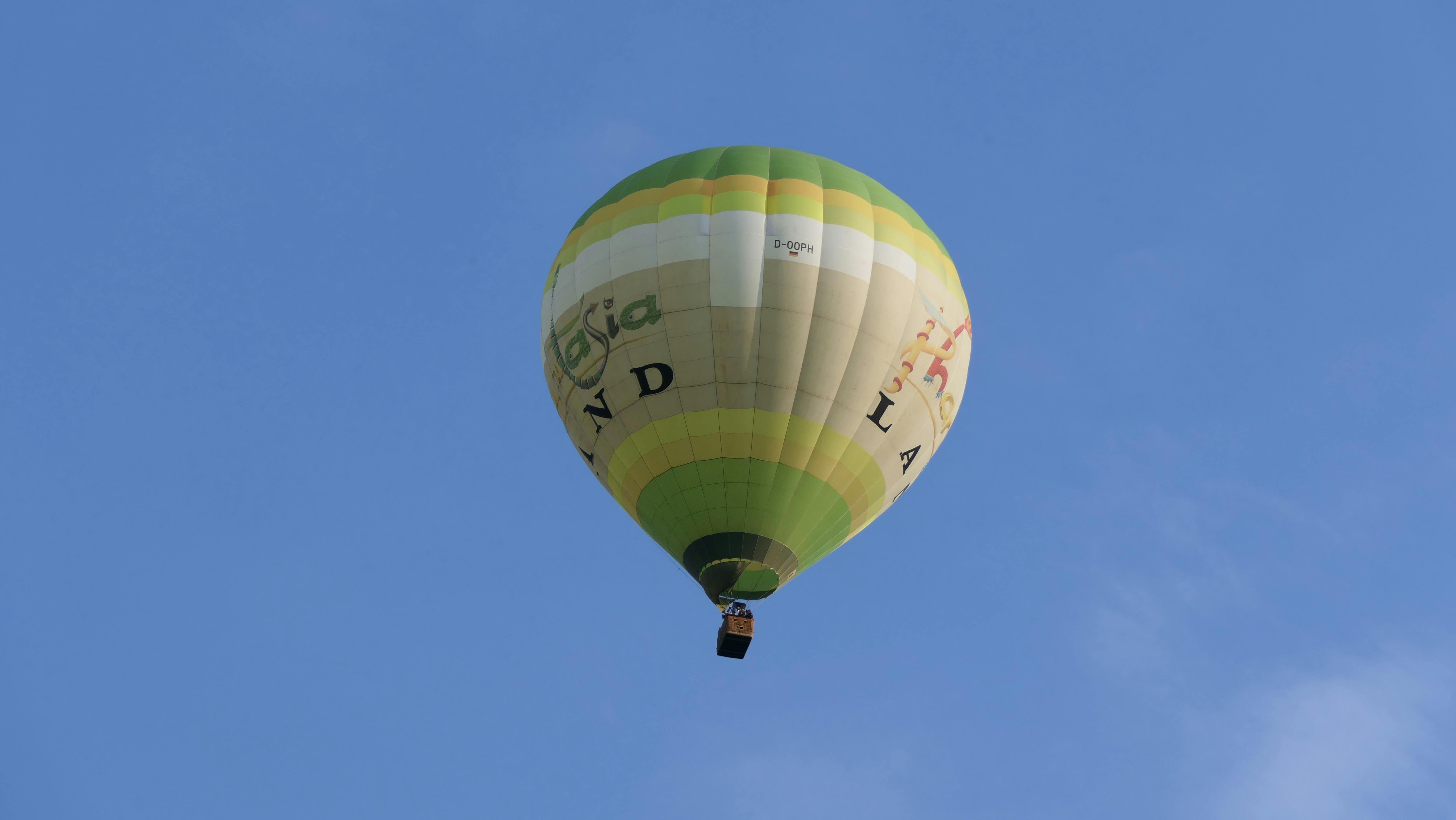 Zadarmo Žiarivo žiariaci teplovzdušný balón unášaný jasnou modrou oblohou v Bonne v Nemecku. Fotka z fotobanky