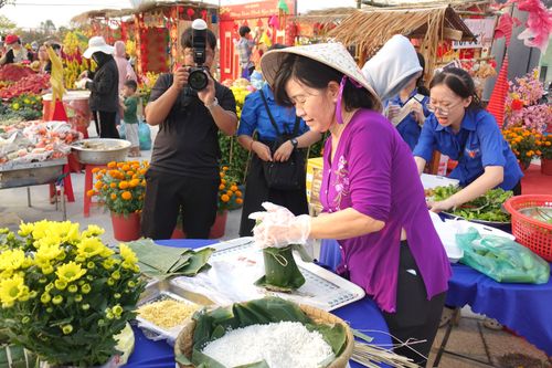 Free A bustling outdoor market with vendors preparing traditional foods amidst colorful flowers. Stock Photo