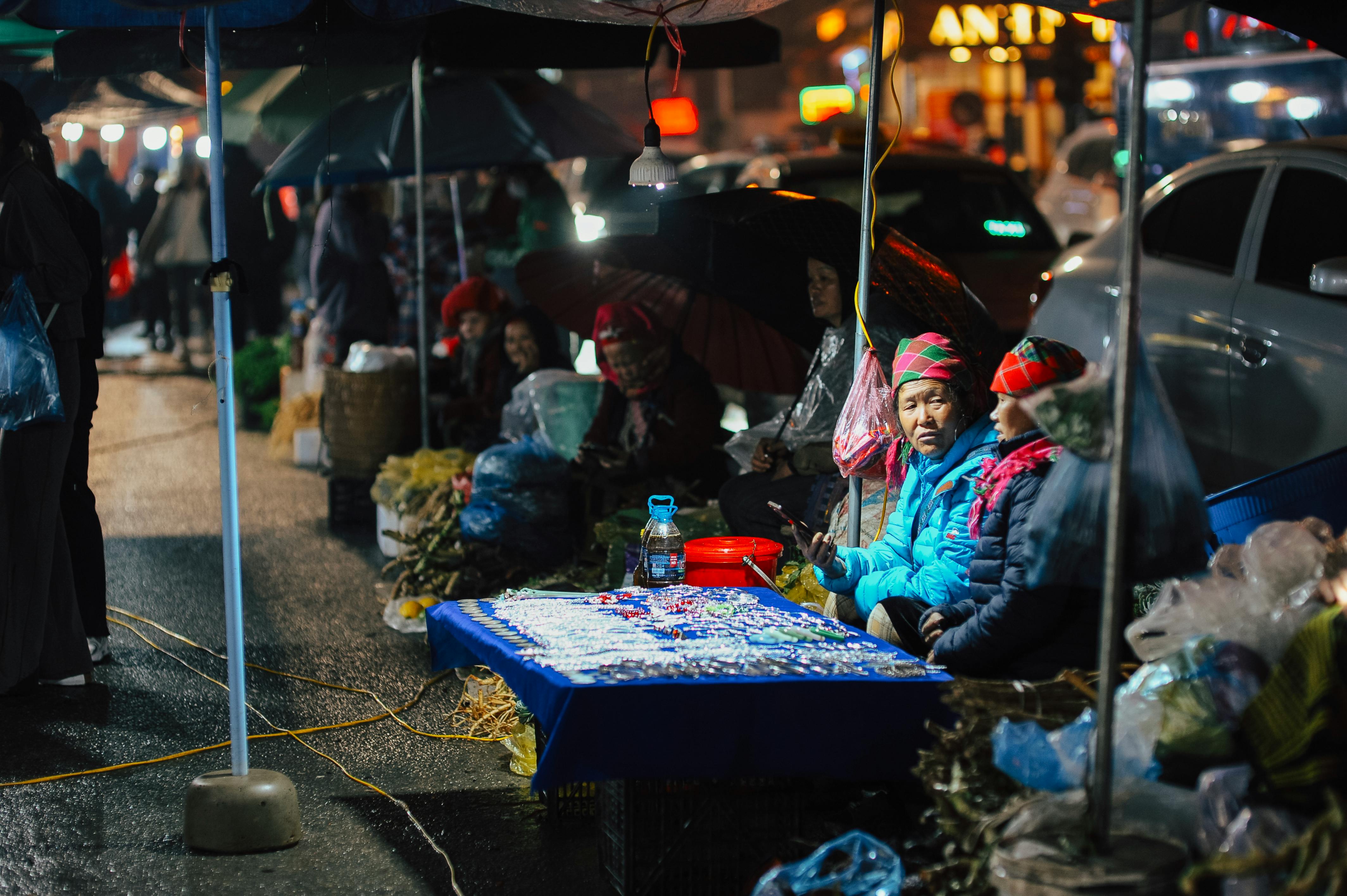 免费 热闹的夜市上，当地商贩们展示着色彩缤纷的帽子和商品。 素材图片