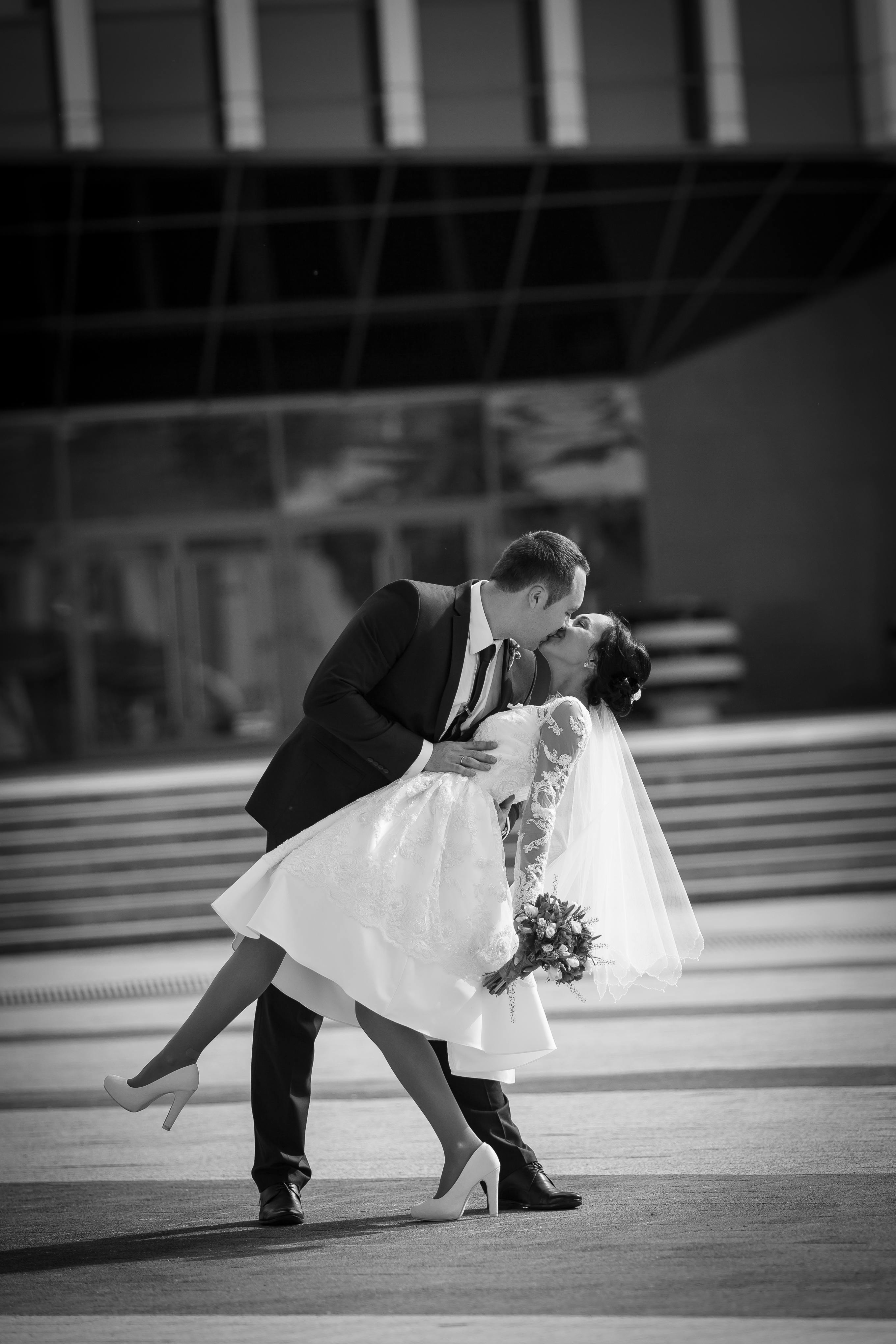 무료 결혼식 날 키스를 나누는 커플의 로맨틱한 흑백 사진. 스톡 사진