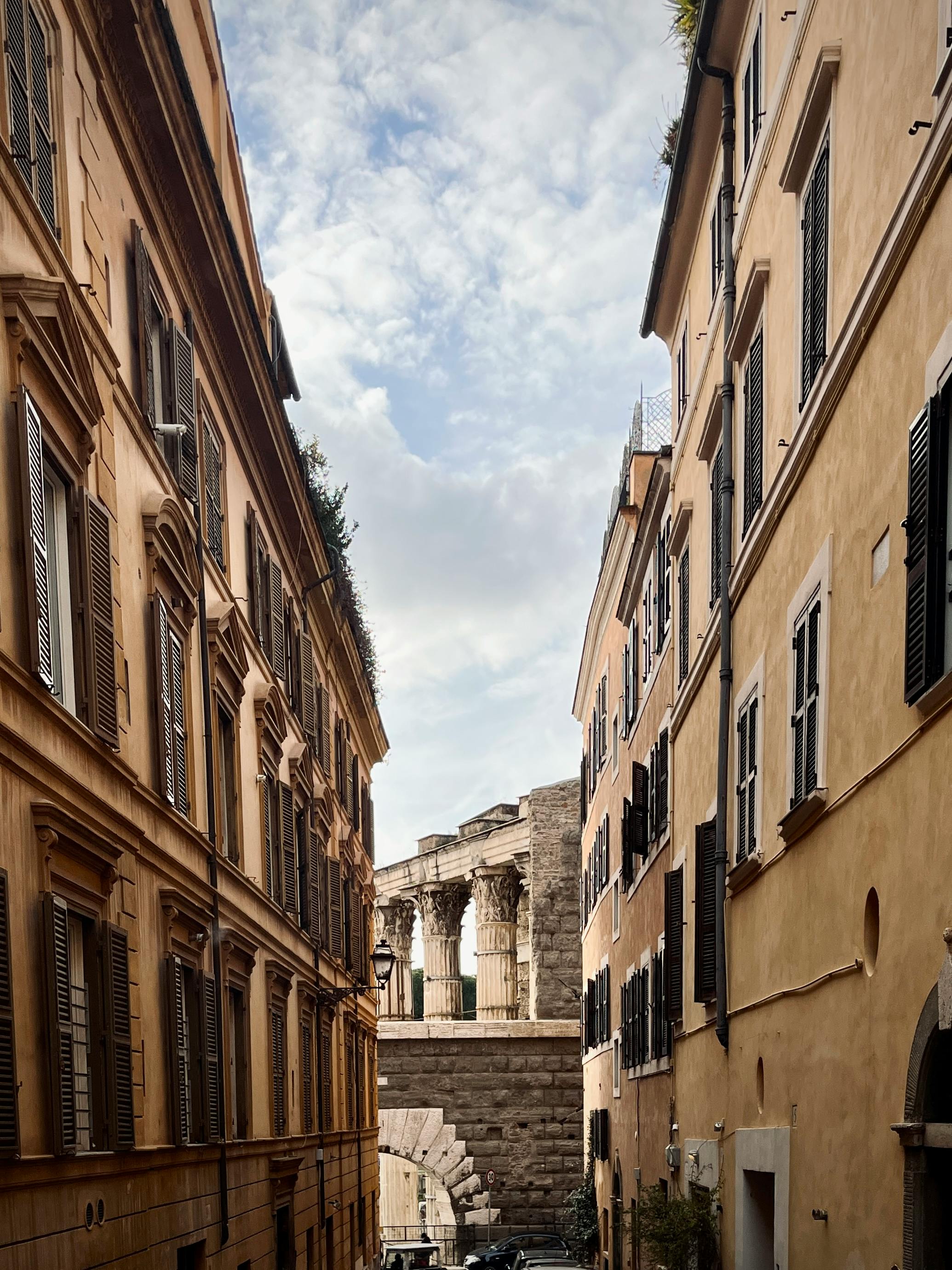 免費 羅馬一條迷人的街道，街上可以看到歷史建築和古老的柱子。 圖庫相片