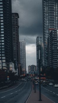 Dramatic view of Mississauga's urban skyline under a moody sky, showcasing modern architecture and city traffic.