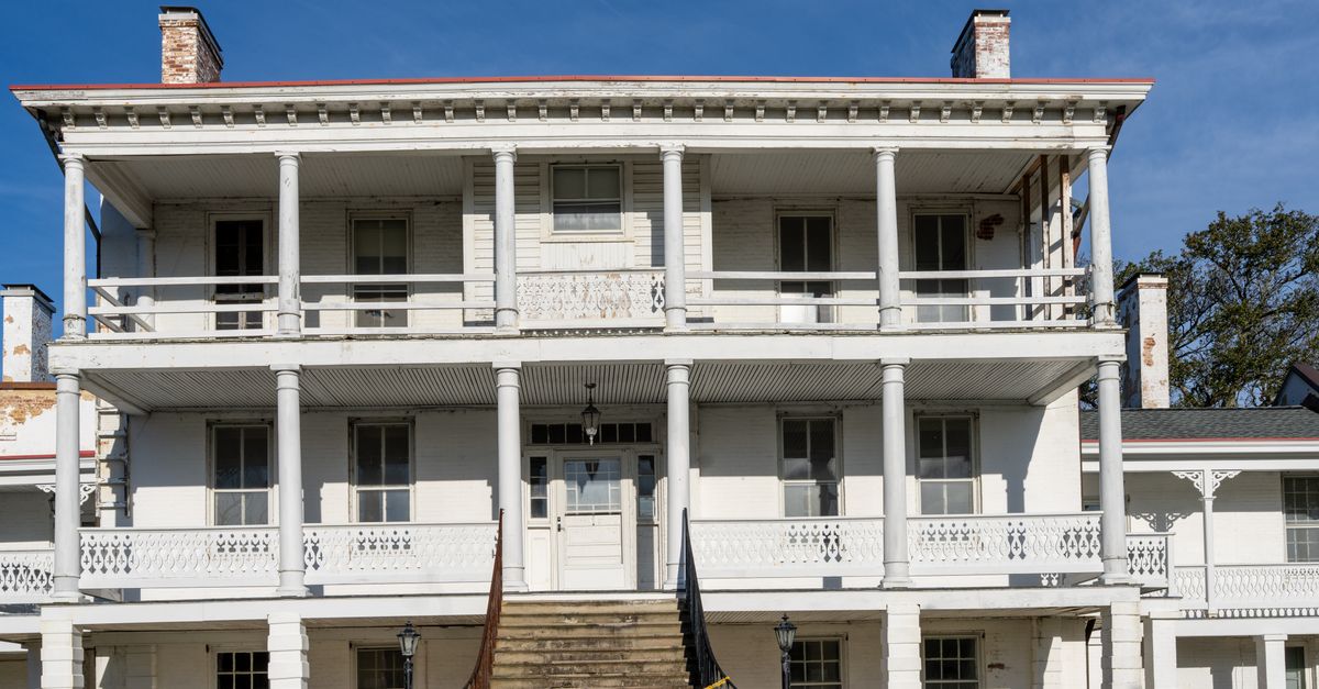 A historic three-story white building in Hampton, Virginia under clear blue skies.