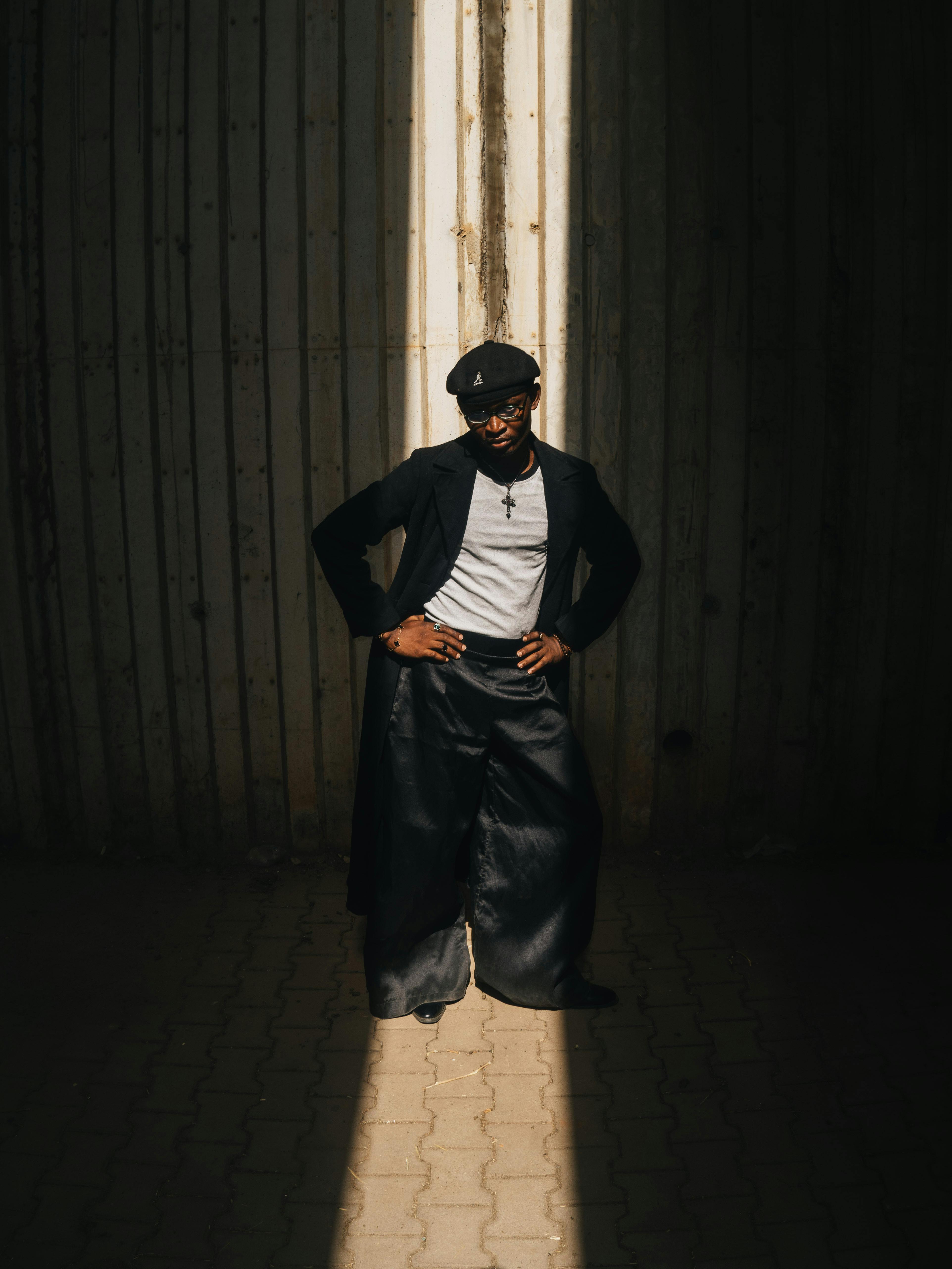 免费 在尼日利亚阿布贾，一位时尚人士在戏剧性的灯光下自信地摆姿势。 素材图片